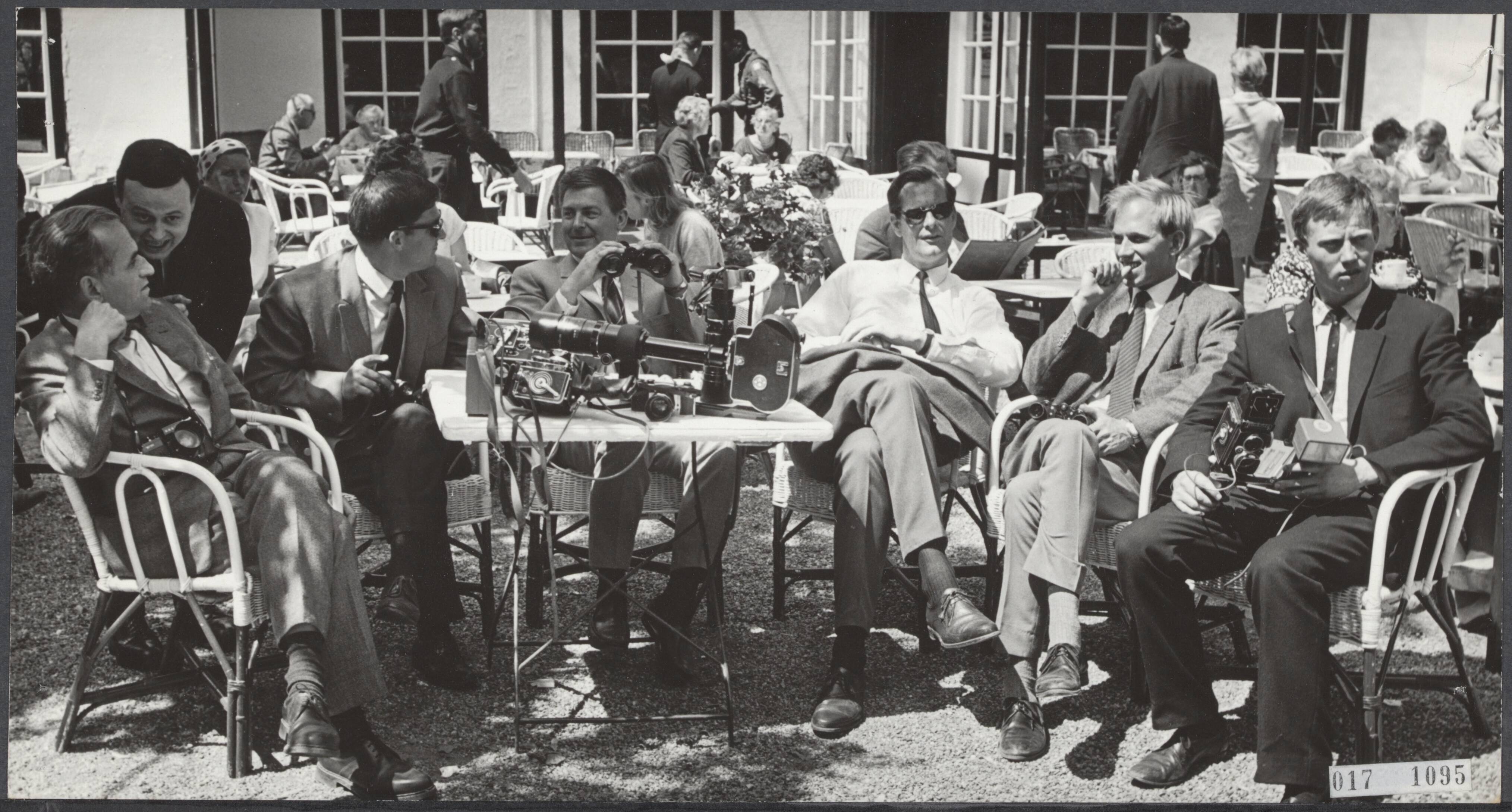 Fotocollectie Elsevier Binnenland — Op Lage Vuursche is het een hele drukte van wachtende verslaggevers en fotograven die allemaal hopen een blik op te vangen van de a.s. verloofde van prinses Beatrix, de heer Claus von Amsberg. Vanaf een terrasje is het voor een aantal persmensen goed wachten — Foto: Koch, Eric / Anefo. Licentie: Set B: Rechtenvrij / Publiek Domein. Bron: Nationaal Archief. http://hdl.handle.net/10648/adbff940-d0b4-102d-bcf8-003048976d84