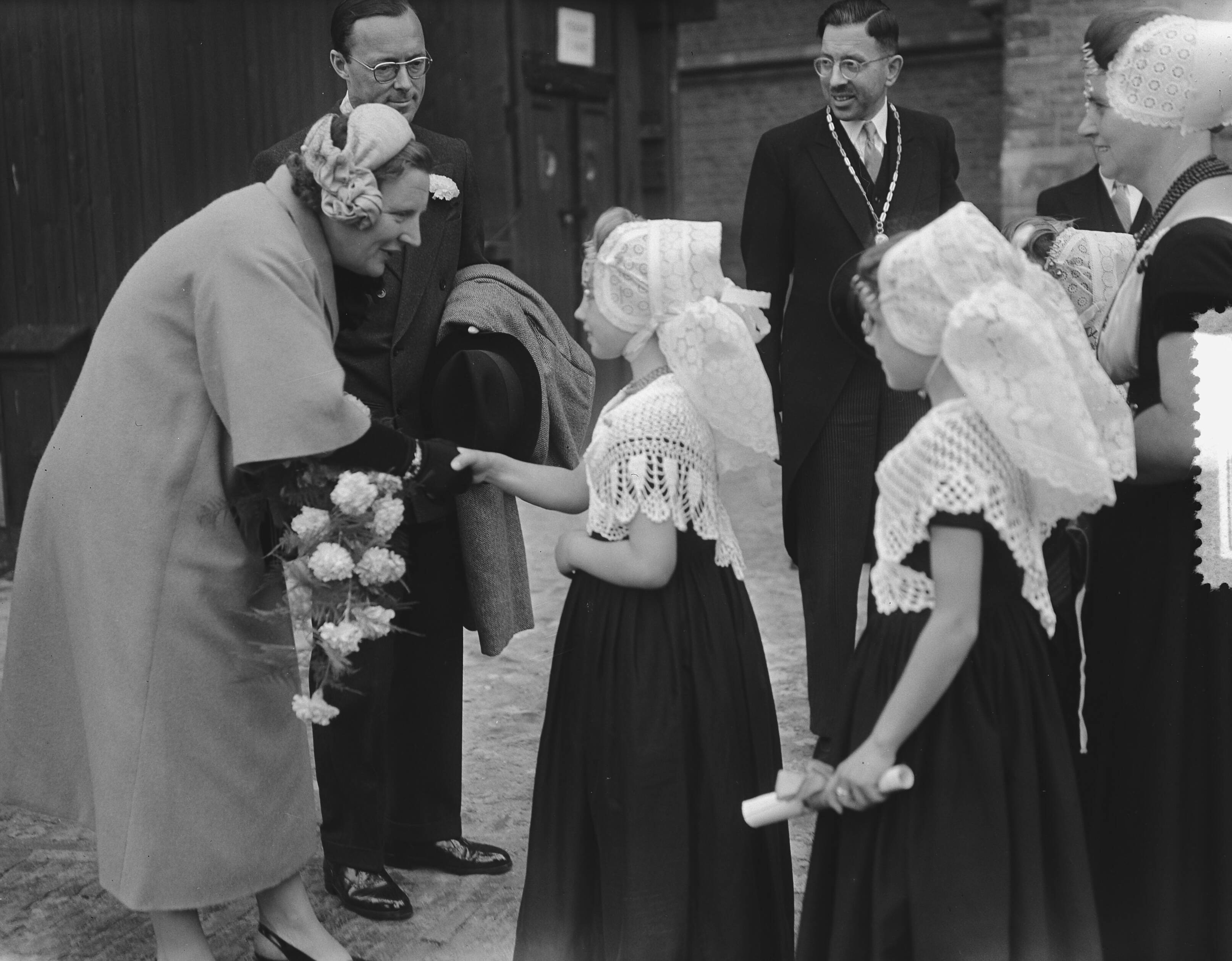 Koningin Juliana en prins Bernhard bezoeken Walcheren — Koningin Juliana ontvangt bloemen uit de handen van meisjes in klederdracht — Foto: Bilsen, Joop van / Anefo. Licentie: Set B: Rechtenvrij / Publiek Domein. Bron: Nationaal Archief. http://hdl.handle.net/10648/a9245700-d0b4-102d-bcf8-003048976d84