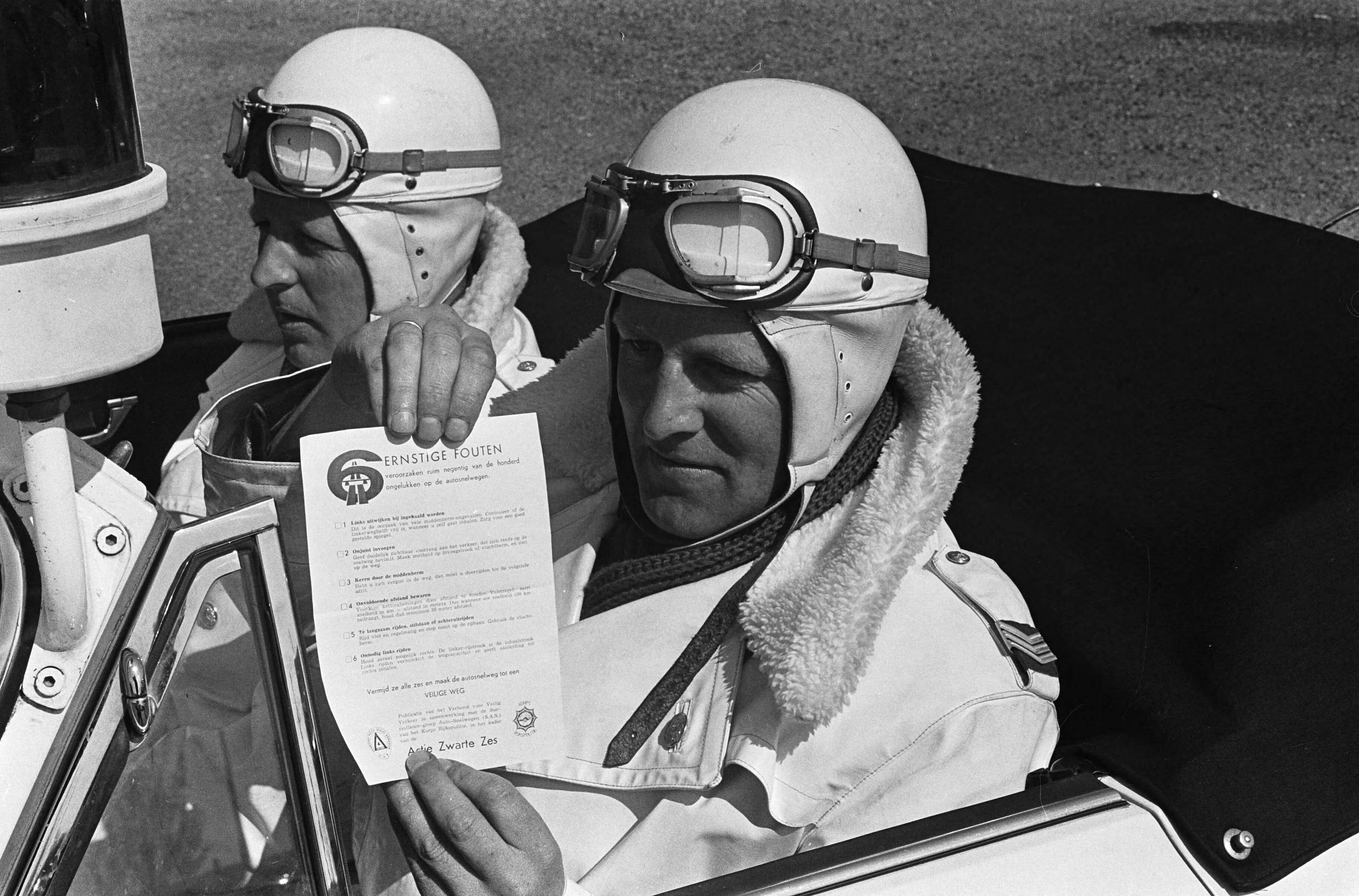 Fotocollectie Anefo — Startsein actie Zwarte Zes van het Verbond voor Veilig Verkeer , een Porschebemanning met het foldertje van de actie — Foto: Pot, Harry / Anefo. Licentie: Set B: Rechtenvrij / Publiek Domein. Bron: Nationaal Archief. http://hdl.handle.net/10648/aa69316c-d0b4-102d-bcf8-003048976d84