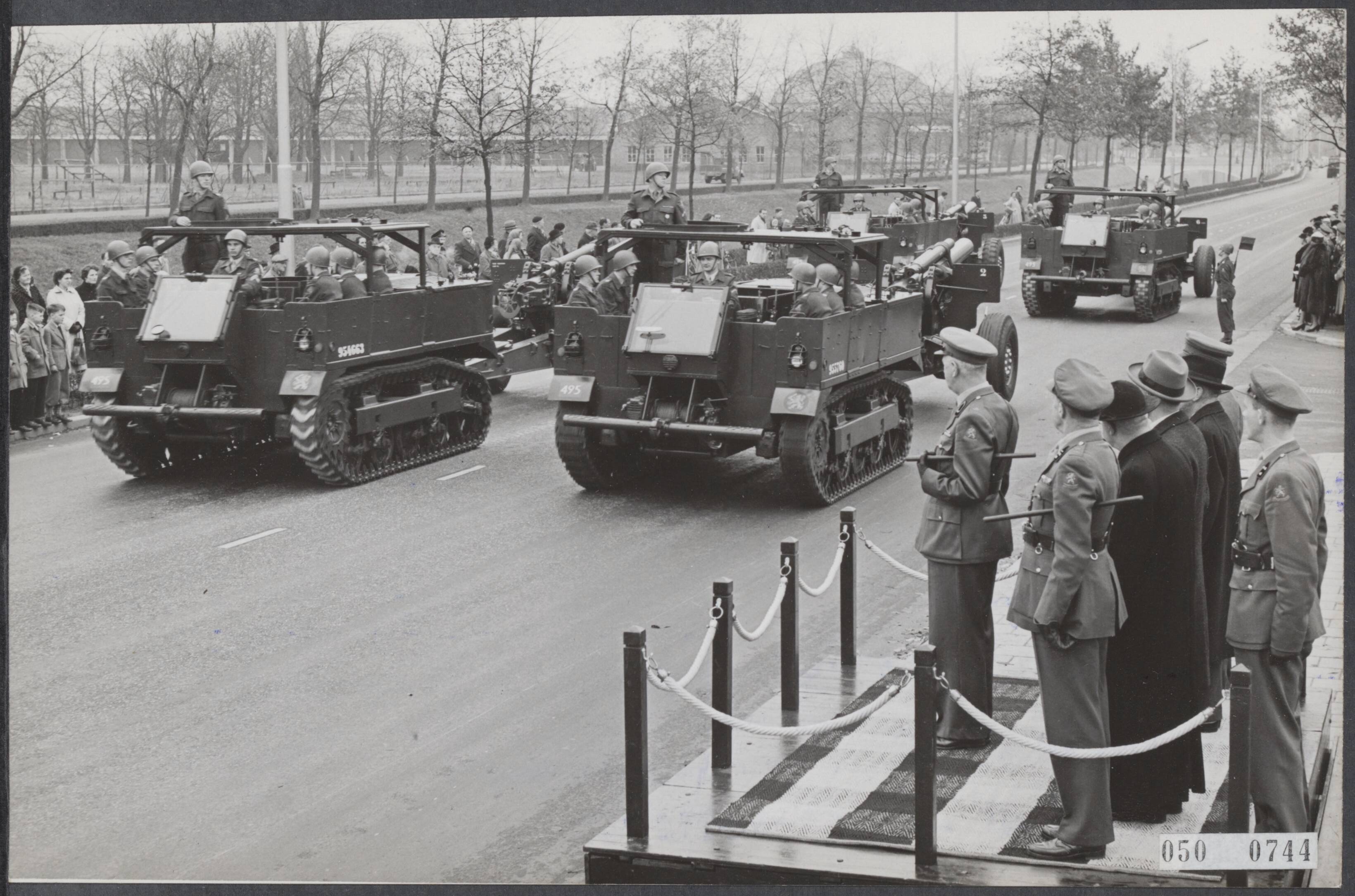 Fotocollectie Elsevier Binnenland — 10-jarig bestaan van de Artillerieschool te Breda. Overzicht van de houwitsers tijdens de parade op de Wilhelminasingel. Op het platform brigade-generaal H.A. Adriaanse — Foto: Fotograaf Onbekend / Anefo. Licentie: Set B: Rechtenvrij / Publiek Domein. Bron: Nationaal Archief. http://hdl.handle.net/10648/ae03b73e-d0b4-102d-bcf8-003048976d84