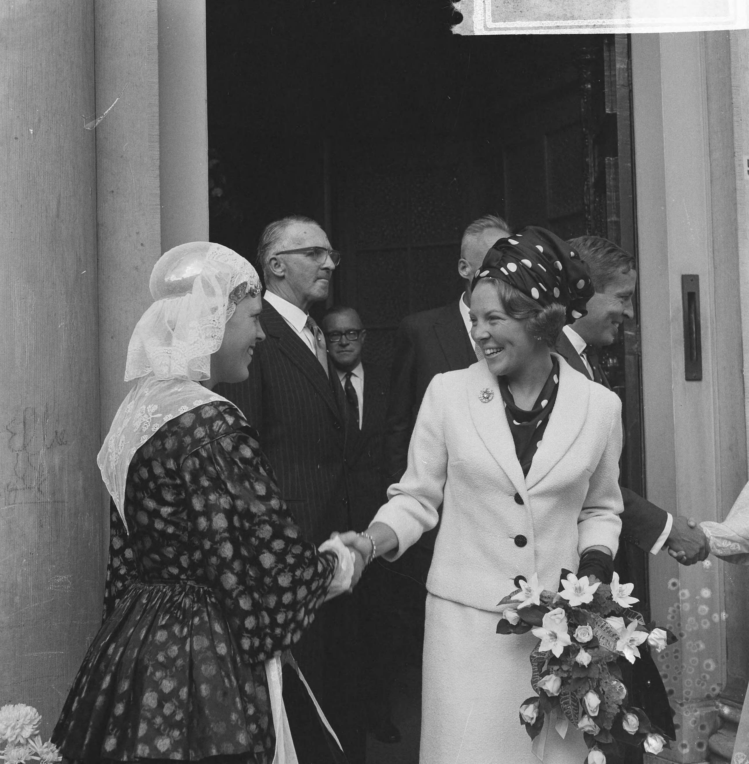 Bezoek van prinses Beatrix en Claus von Amsberg aan de drie noordelijke provincies — Bezoek prinses Beatrix en haar verloofde Claus von Amsberg aan Leeuwarden, prinses Beatrix schudt de hand van een meisje in Friese klederdracht bij de ingang van het Provinciehuis — Foto: Kroon, Ron / Anefo. Licentie: Set B: Rechtenvrij / Publiek Domein. Bron: Nationaal Archief. http://hdl.handle.net/10648/aabefebc-d0b4-102d-bcf8-003048976d84