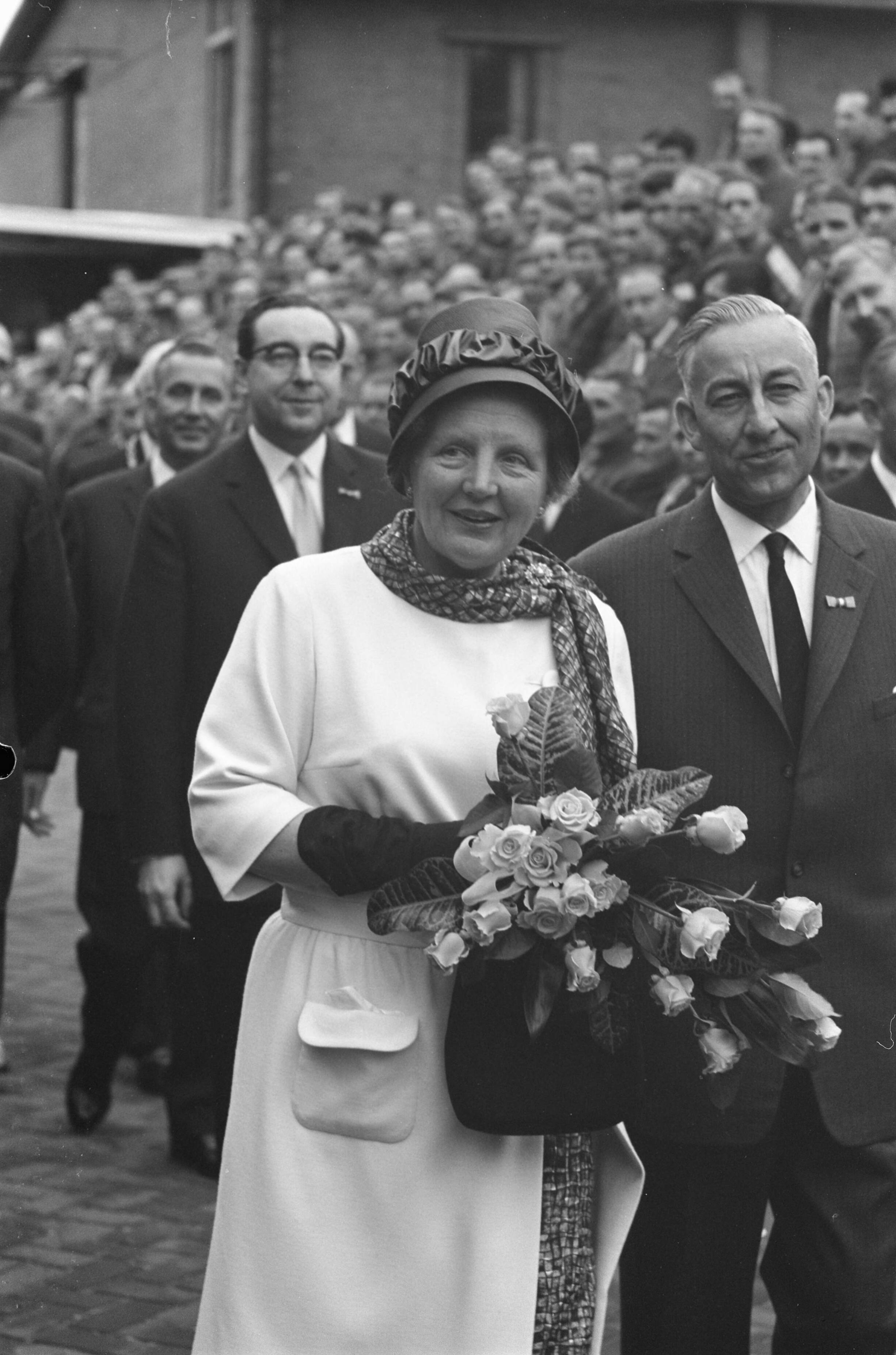 Bezoek koningin Juliana aan Zeist en omgeving — Bezoek koningin Juliana aan Zeist en omgeving. De koningin met bloemen tijdens haar bezoek aan de Gerofabriek — Foto: Pot, Harry / Anefo. Licentie: Set B: Rechtenvrij / Publiek Domein. Bron: Nationaal Archief. http://hdl.handle.net/10648/a9d73a96-d0b4-102d-bcf8-003048976d84