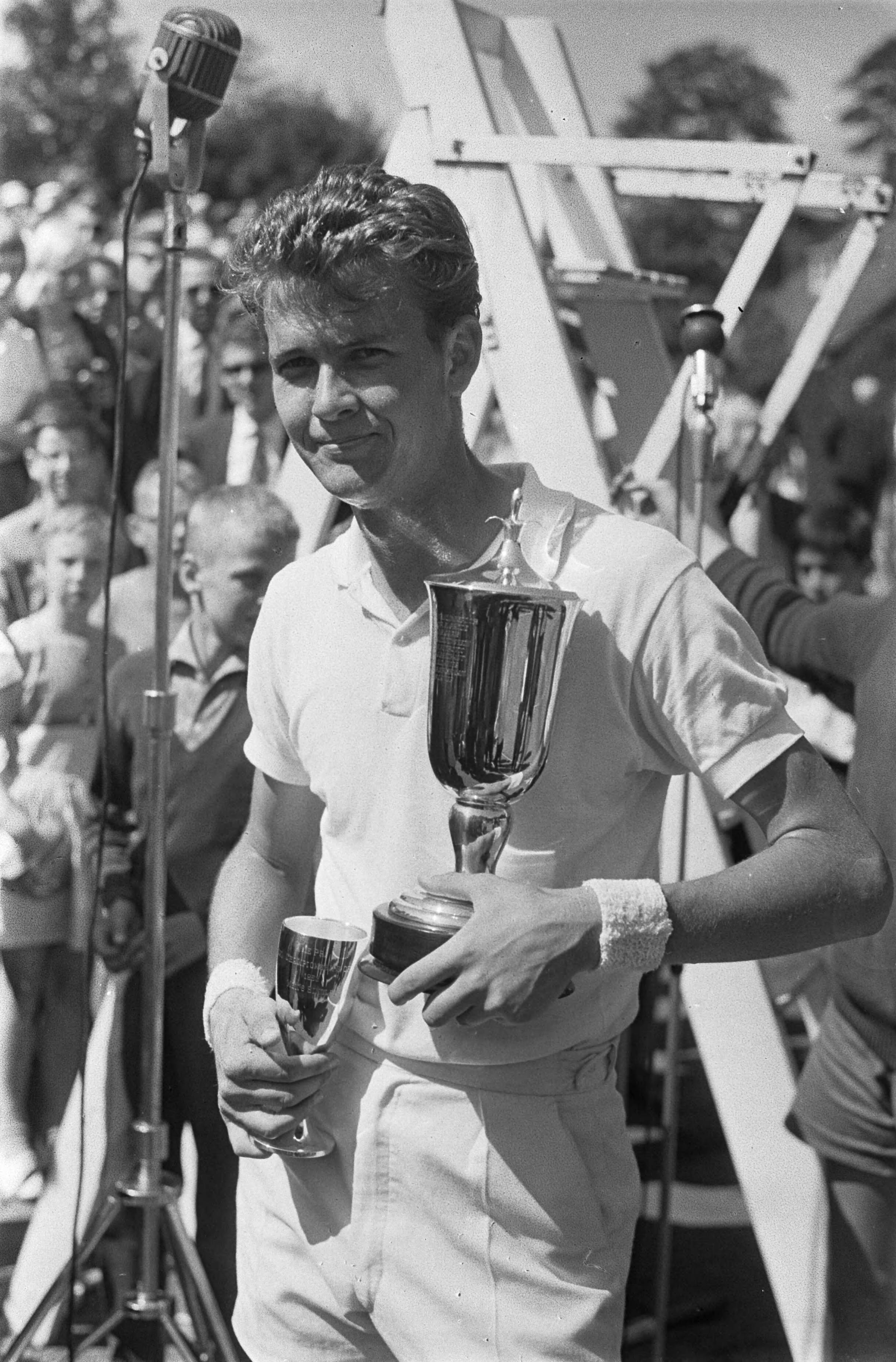 Fotocollectie Anefo — Tennis te Hilversum. De winnaar van het heren enkel de Zuid-AFrikaan Cliff Drysdale met zijn trofeeën — Foto: Gelderen, Hugo van / Anefo. Licentie: Set B: Rechtenvrij / Publiek Domein. Bron: Nationaal Archief. http://hdl.handle.net/10648/aa3ff234-d0b4-102d-bcf8-003048976d84