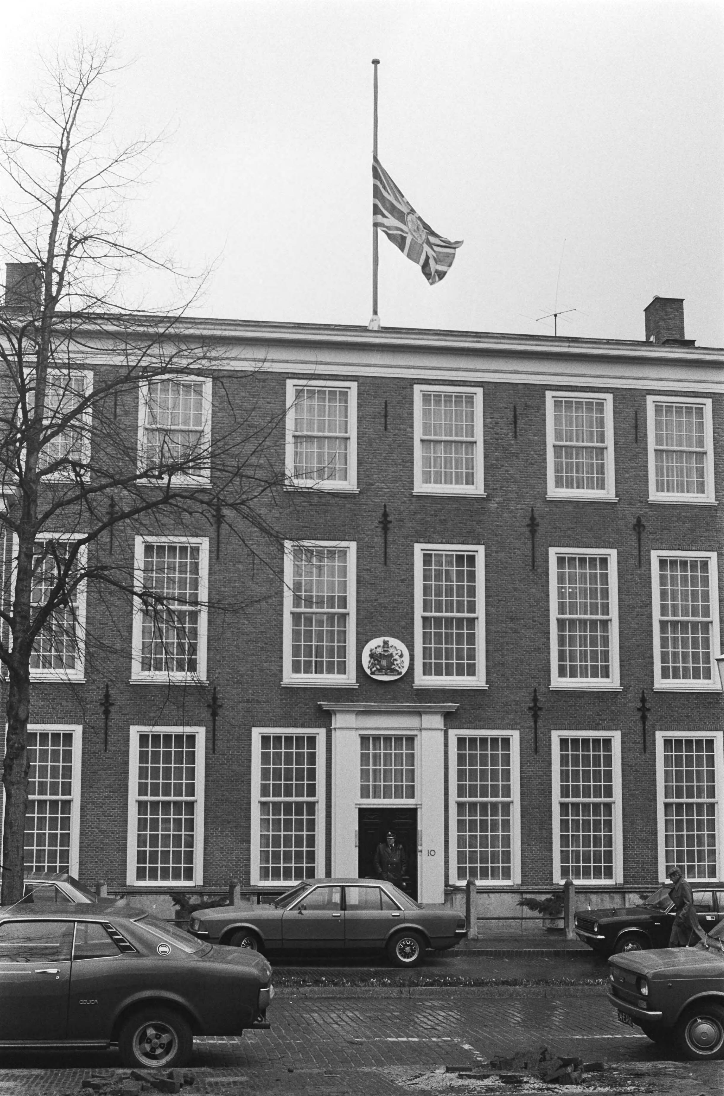 Britse ambassadeur Sir Richard Sykes in Den Haag vermoord — De Britse ambassade met de vlag half stok — Foto: Suyk, Koen / Anefo. Licentie: Set B: Rechtenvrij / Publiek Domein. Bron: Nationaal Archief. http://hdl.handle.net/10648/acc6b772-d0b4-102d-bcf8-003048976d84