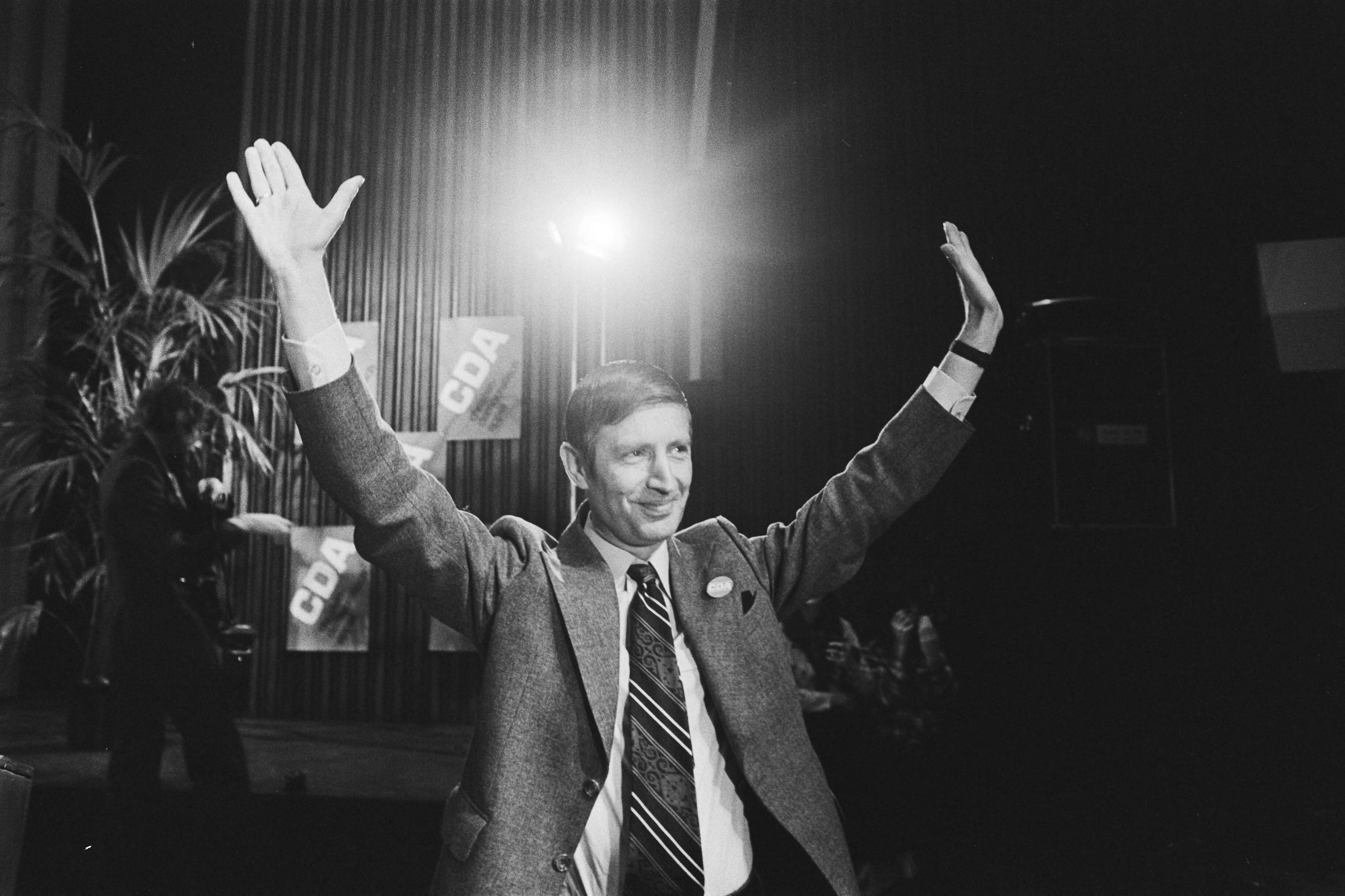 Fotocollectie Anefo — CDA-congres in Den Haag (2e dag); minister Van Agt met omhooggestoken armen, dankt voor applaus — Foto: Verhoeff, Bert / Anefo. Licentie: Set B: Rechtenvrij / Publiek Domein. Bron: Nationaal Archief. http://hdl.handle.net/10648/ac91d246-d0b4-102d-bcf8-003048976d84