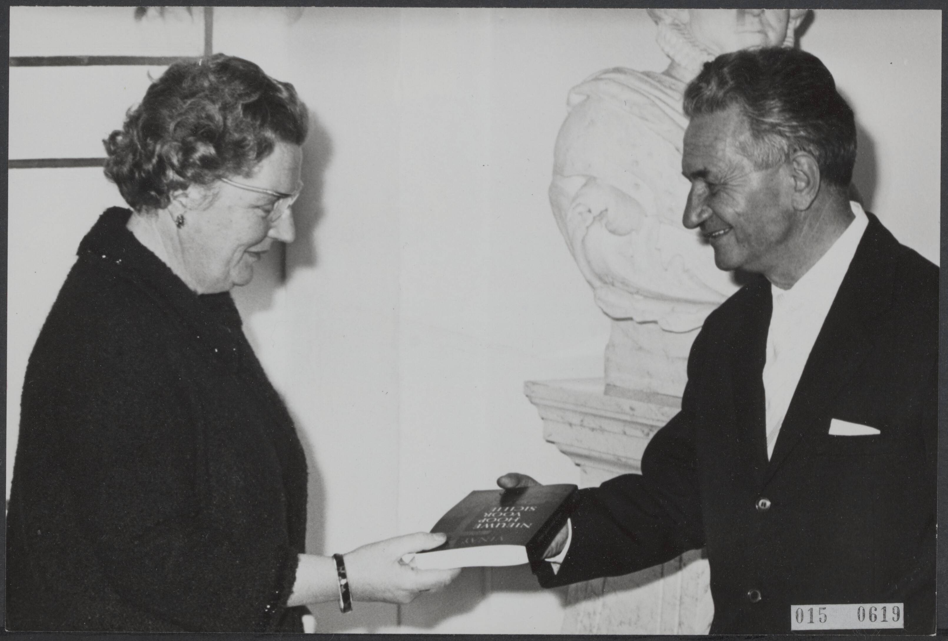 Fotocollectie Elsevier Binnenland — Koningin Juliana ontving ds. Tullie Viney op paleis Soestdijk. Dominee Viney verricht op Sicilië samen met zijn echtgenote ontwikkelingswerk. Zij hebben daar o.m. een kippenfarm gevestigd. De koningin krijgt de Nederlandse uitgave van het boek van dominee Tullie Viney, genaamd "Nieuwe hoop voor Sicilië" — Foto: Kroon, Ron / Anefo. Licentie: Set B: Rechtenvrij / Publiek Domein. Bron: Nationaal Archief. http://hdl.handle.net/10648/adb5a12a-d0b4-102d-bcf8-003048976d84