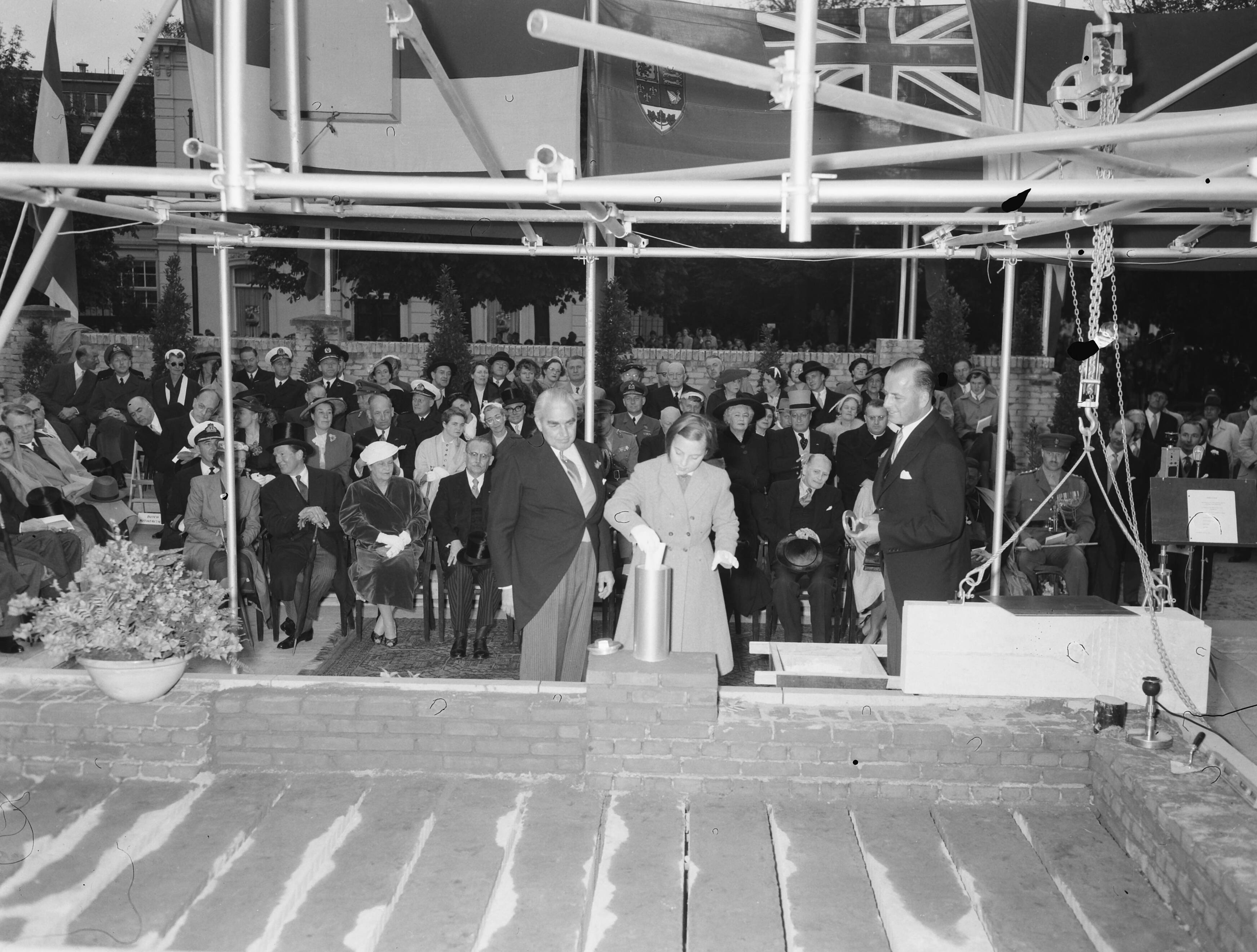 Prinses Margriet legt eerste steen van het nieuwe gebouw van de kanselarij van de Canadese ambassade te Den Haag — Prinses Margriet legt eerste steen van het nieuwe gebouw van kanselarij van de Canadese ambassade te Den Haag, geassisteerd door ambassadeur Thomas A. Stone (l) en ir F. Brouwer, directeur van de bouwmaatschappij — Foto: Noske, J.D. / Anefo. Licentie: Set B: Rechtenvrij / Publiek Domein. Bron: Nationaal Archief. http://hdl.handle.net/10648/a9369bae-d0b4-102d-bcf8-003048976d84