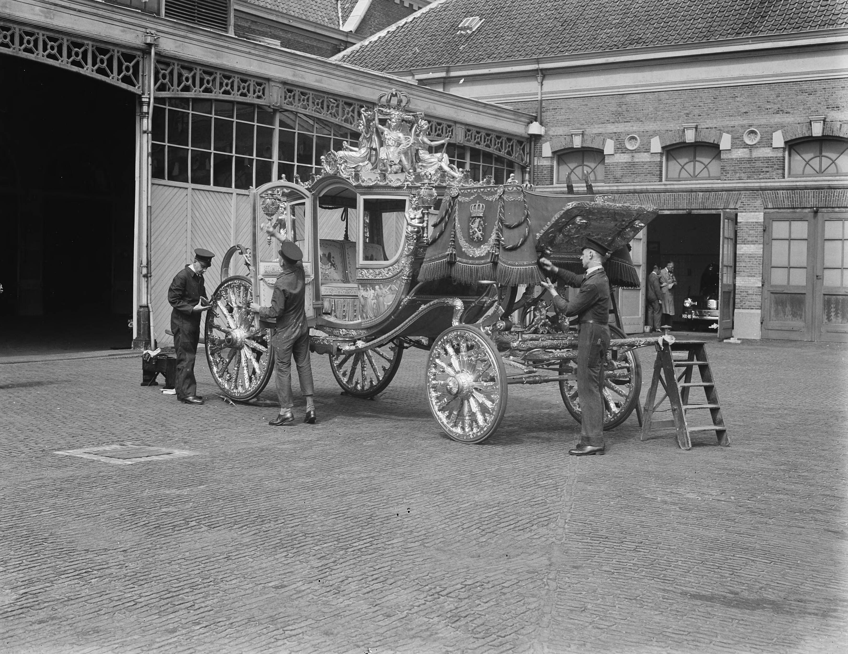 Koninklijke Stallen te Den Haag. Voorbereidingen viering Regeringsjubileum — Koninklijks Stallen te Den Haag. Gouden Koets wordt schoongemaakt — Foto: Merk, Ben / Anefo. Licentie: Set B: Rechtenvrij / Publiek Domein. Bron: Nationaal Archief. http://hdl.handle.net/10648/a8babcd2-d0b4-102d-bcf8-003048976d84