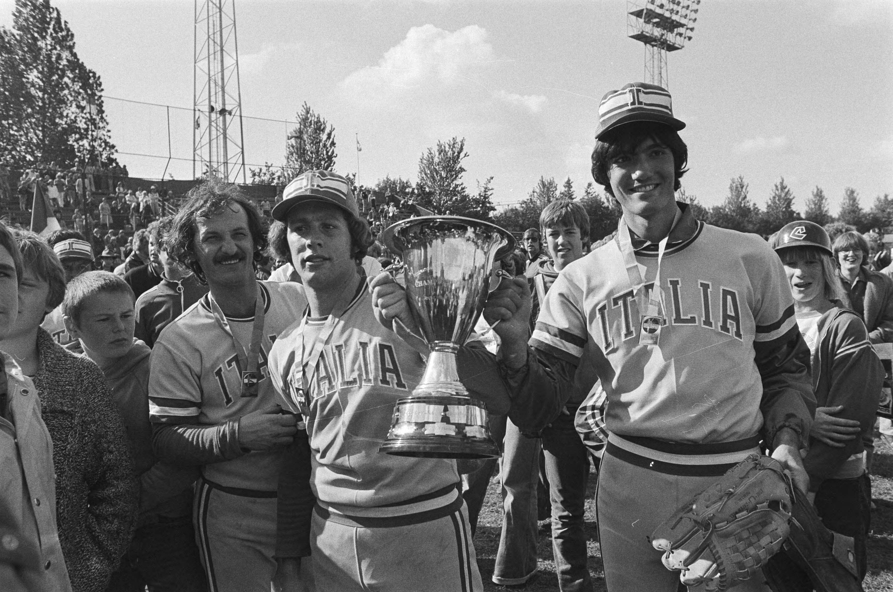 Fotocollectie Anefo — EK honkbal in Haarlem, Italie tegen Nederland 1-0, Italiaanse spelers met beker — Foto: Peters, Hans / Anefo. Licentie: Set B: Rechtenvrij / Publiek Domein. Bron: Nationaal Archief. http://hdl.handle.net/10648/aca0490c-d0b4-102d-bcf8-003048976d84