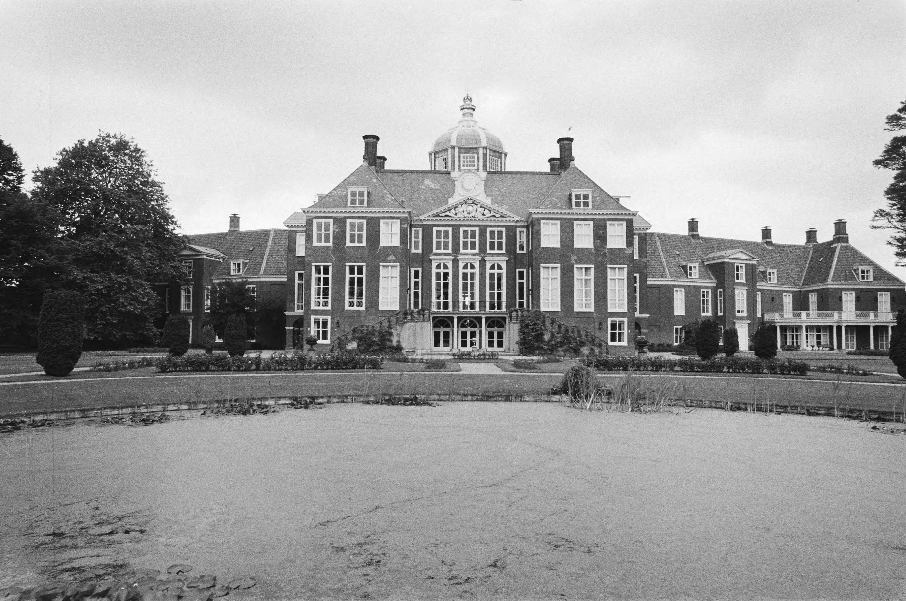 Fotocollectie Anefo — Pers-excursie in Koninklijk Paleis Het Huis ten Bosch i Den Haag waar Beatrix eind van de zomer zal gaan wonen; exterieur gezien vanuit de tuin — Foto: Antonisse, Marcel / Anefo. Licentie: Set B: Rechtenvrij / Publiek Domein. Bron: Nationaal Archief. http://hdl.handle.net/10648/acfd9cce-d0b4-102d-bcf8-003048976d84