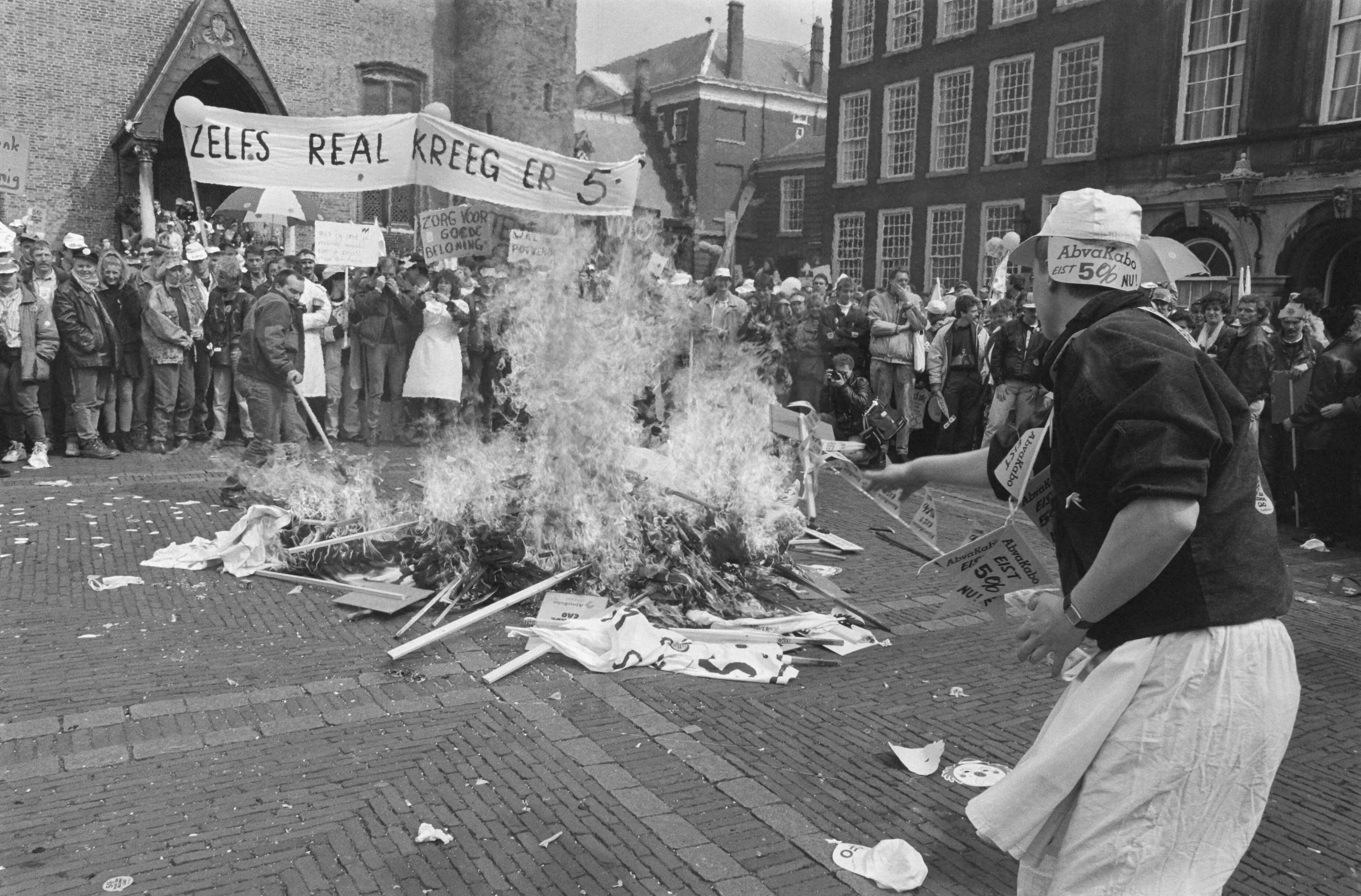 Demonstratie meer dan 50.000 verpleegkundigen in Den Haag — Op het Binnenhof worden spandoeken verbrand — Foto: Croes, Rob C. / Anefo. Licentie: Set B: Rechtenvrij / Publiek Domein. Bron: Nationaal Archief. http://hdl.handle.net/10648/ad7247ae-d0b4-102d-bcf8-003048976d84