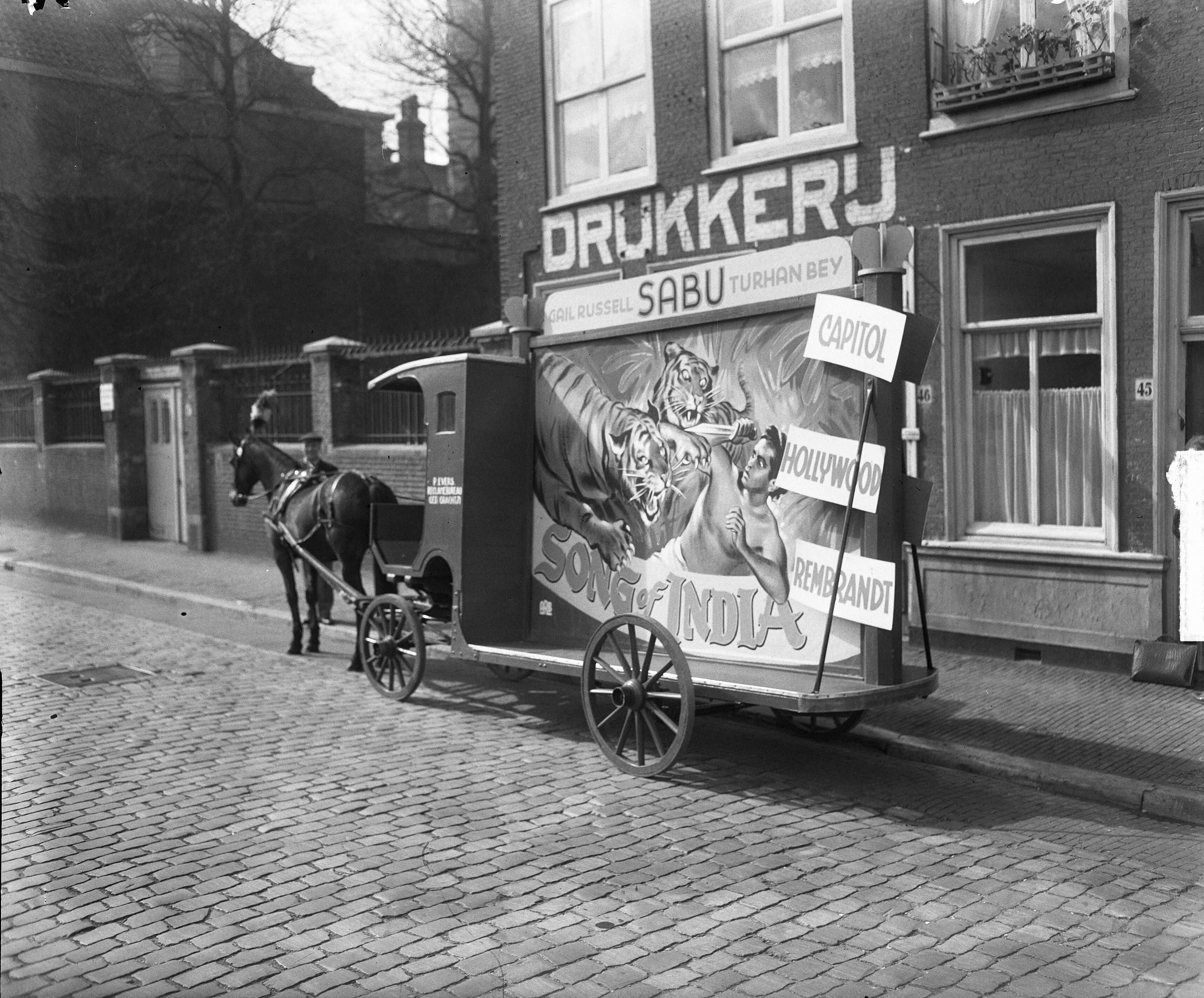Fotocollectie Anefo — Rijdende reclame met paard en wagen voor de film "Song of India" — Foto: Winterbergen, Rolf / Anefo. Licentie: Set B: Rechtenvrij / Publiek Domein. Bron: Nationaal Archief. http://hdl.handle.net/10648/a8d6ff0a-d0b4-102d-bcf8-003048976d84