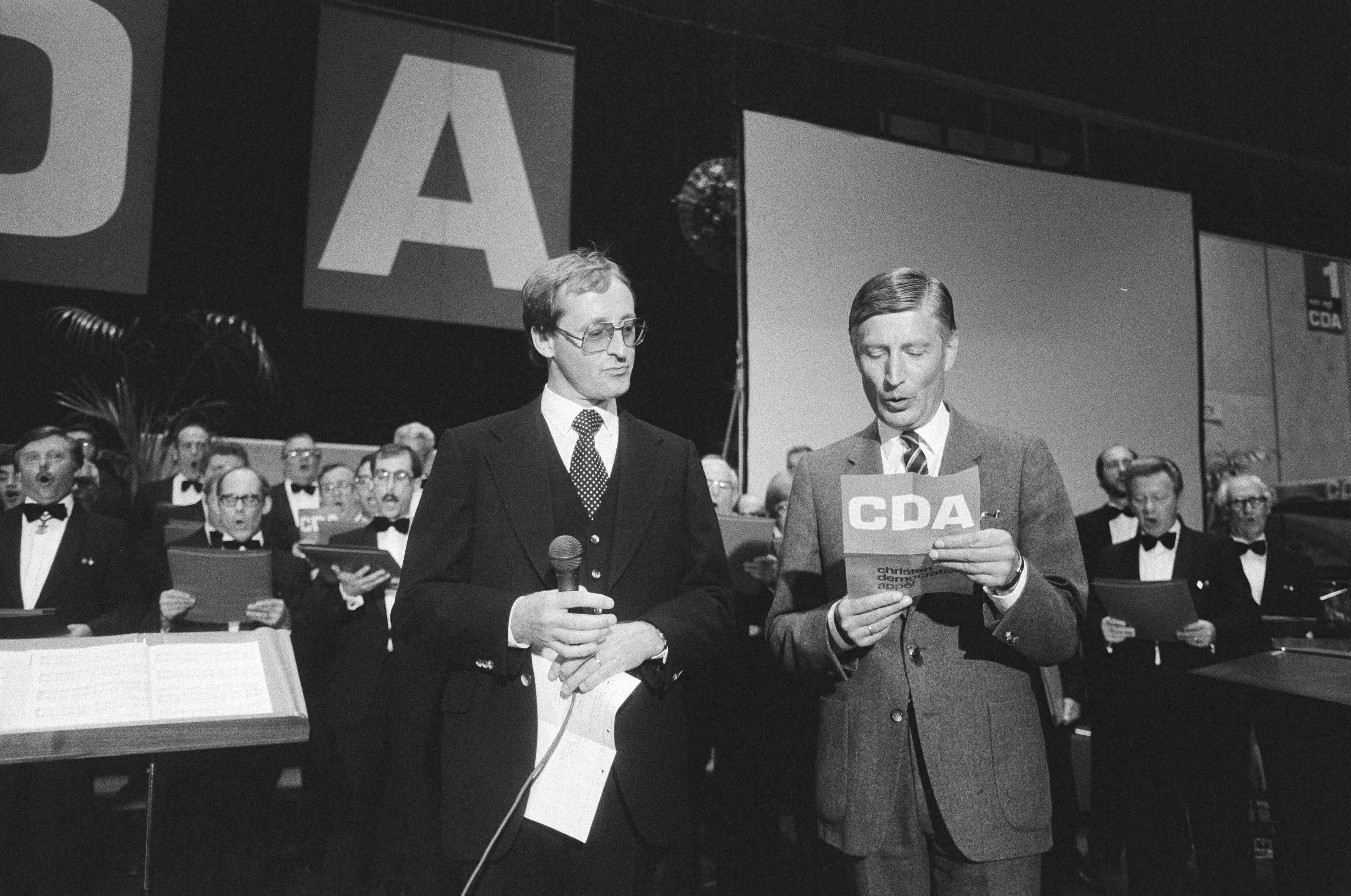 Fotocollectie Anefo — Tevens opdracht CDA, verkiezingsbijeenkomst CDA in Kerkrade Van Agt tijdens zingen Limburgs Volkslied — Foto: Bogaerts, Rob / Anefo. Licentie: Set B: Rechtenvrij / Publiek Domein. Bron: Nationaal Archief. http://hdl.handle.net/10648/ad1dcbde-d0b4-102d-bcf8-003048976d84