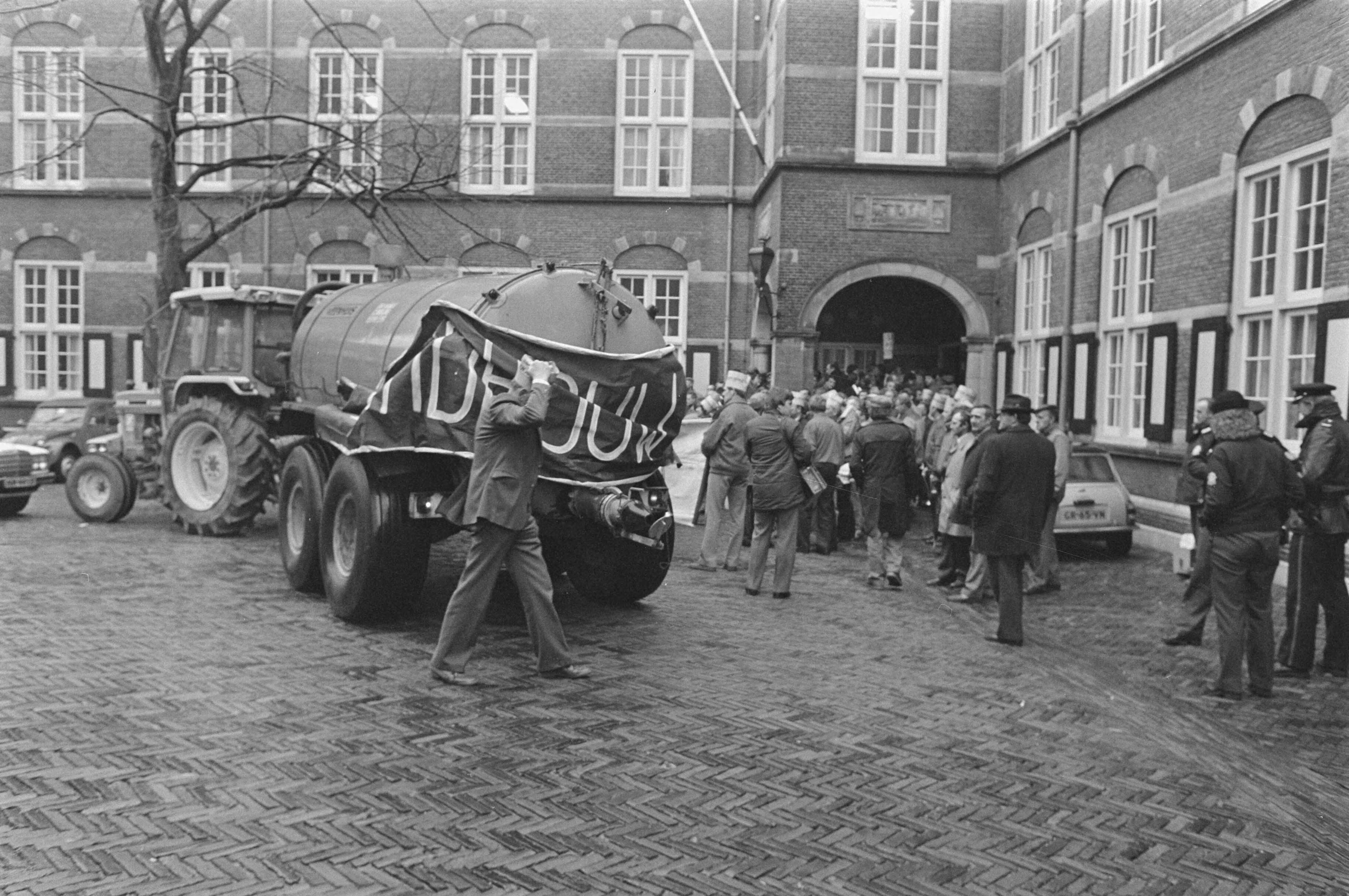 Actievoerende boeren op het Binnenhof in Den Haag i.v.m. de nieuwe meststoffenwet. — Een mestkar wordt het Binnenhof opgereden — Foto: Croes, Rob C. / Anefo. Licentie: Set B: Rechtenvrij / Publiek Domein. Bron: Nationaal Archief. http://hdl.handle.net/10648/ad520b38-d0b4-102d-bcf8-003048976d84