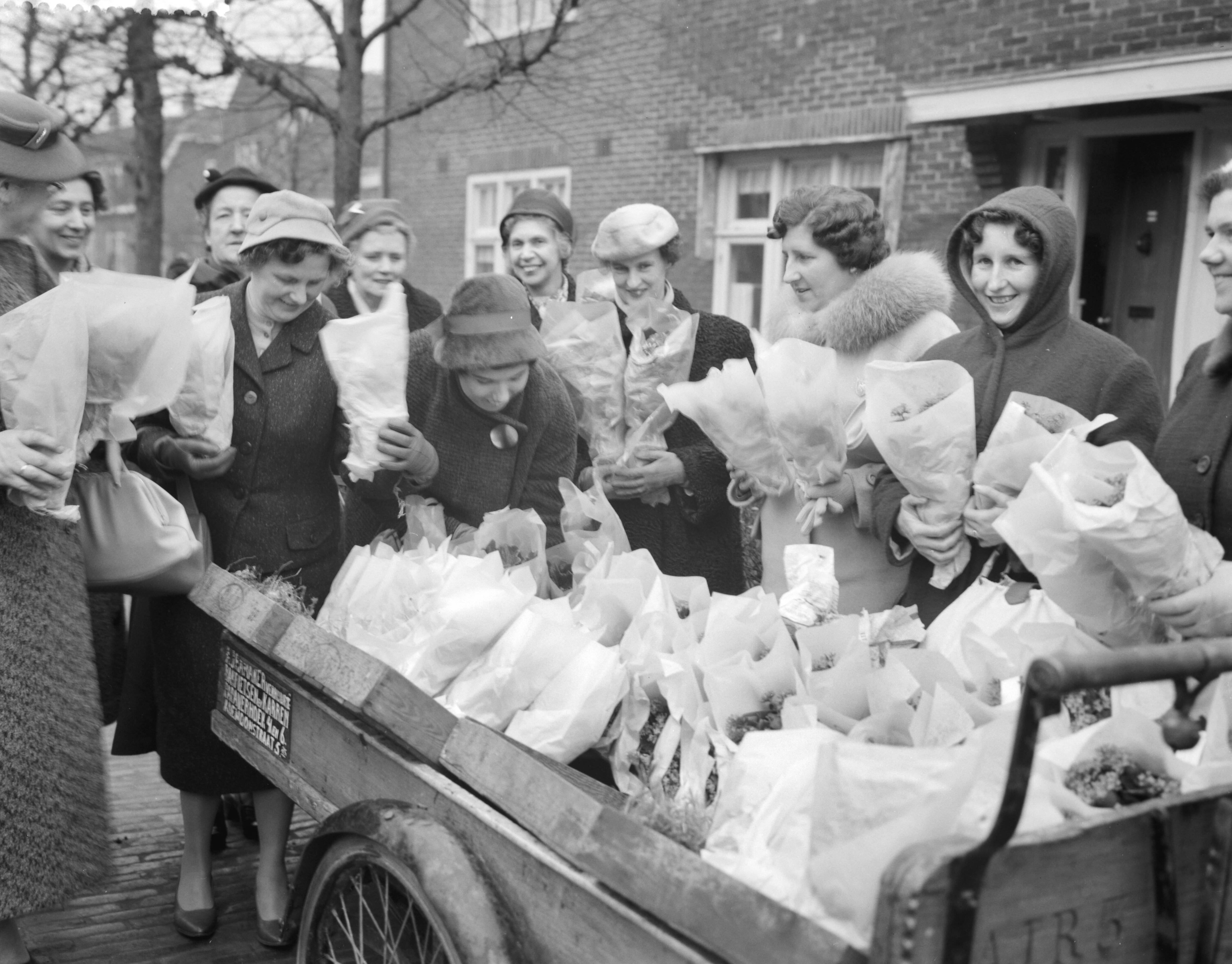 Fotocollectie Anefo — Vrouwen van Schouwen-Duiveland schenken bloemen aan Tuindorp Oostzaan. Vrouwen delen bloemen uit — Foto: Rossem, Wim van / Anefo. Licentie: Set B: Rechtenvrij / Publiek Domein. Bron: Nationaal Archief. http://hdl.handle.net/10648/a9a7ee6c-d0b4-102d-bcf8-003048976d84