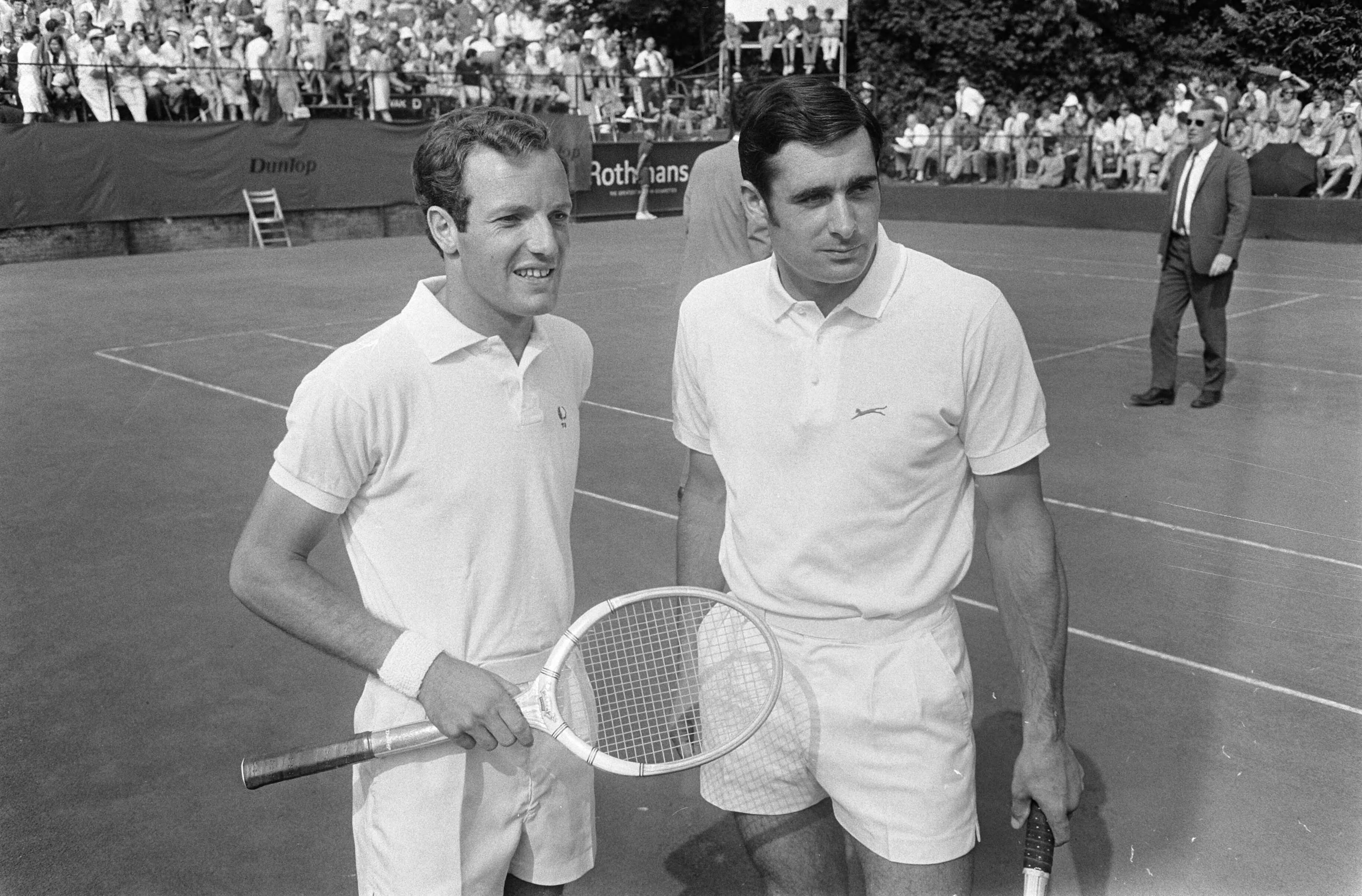 Open Nederlandse Tenniskampioenschappen 1969 in Hilversum — Tom Okker (l) en Roger Taylor (Engeland) — Foto: Fotograaf Onbekend / Anefo. Licentie: Set B: Rechtenvrij / Publiek Domein. Bron: Nationaal Archief. http://hdl.handle.net/10648/ab750bda-d0b4-102d-bcf8-003048976d84