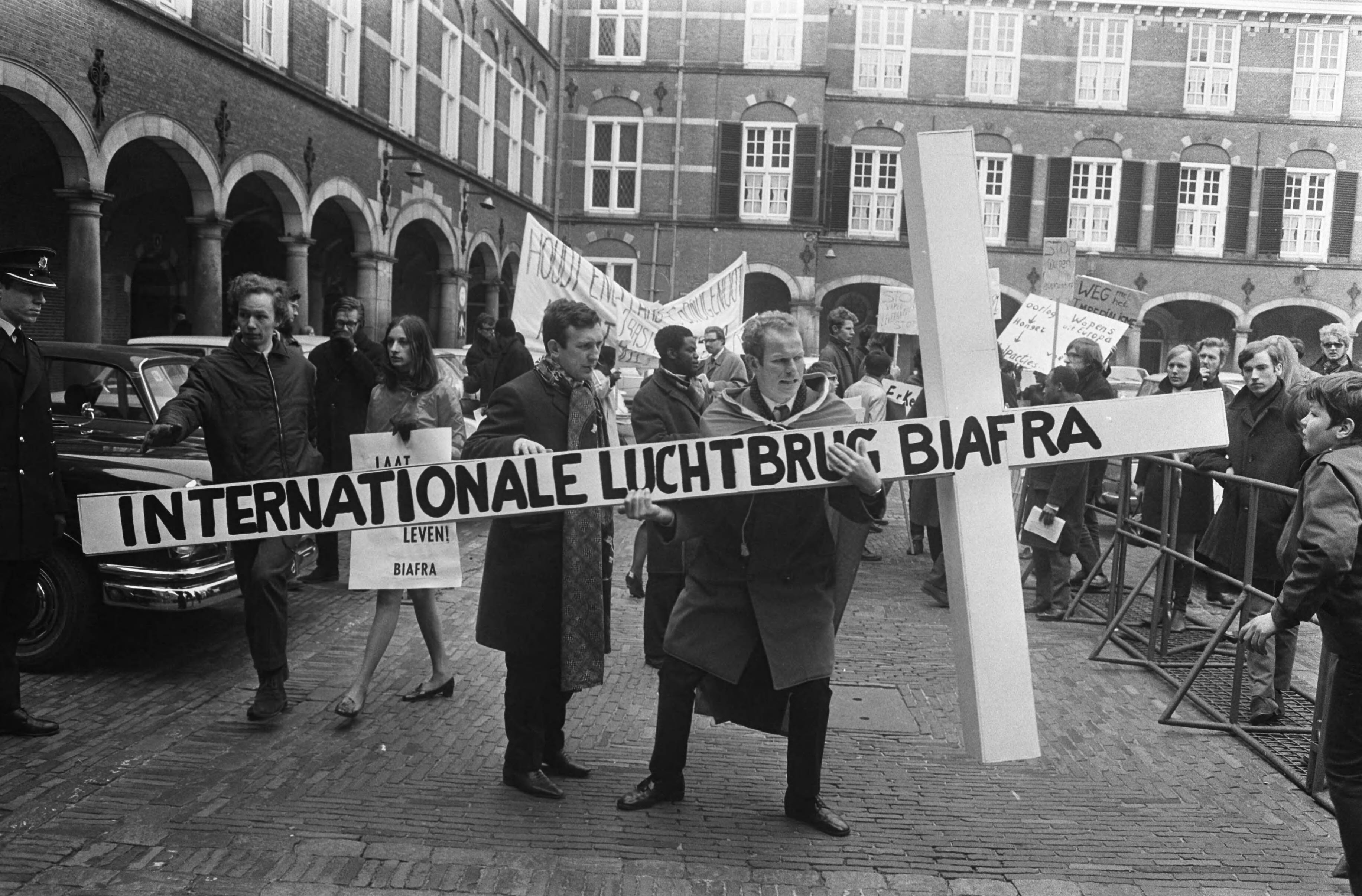 Fotocollectie Anefo — Demonstratie voor Biafra op Binnenhof Den Haag demonstrant met groot kruis — Foto: Koch, Eric / Anefo. Licentie: Set B: Rechtenvrij / Publiek Domein. Bron: Nationaal Archief. http://hdl.handle.net/10648/ab5fd544-d0b4-102d-bcf8-003048976d84