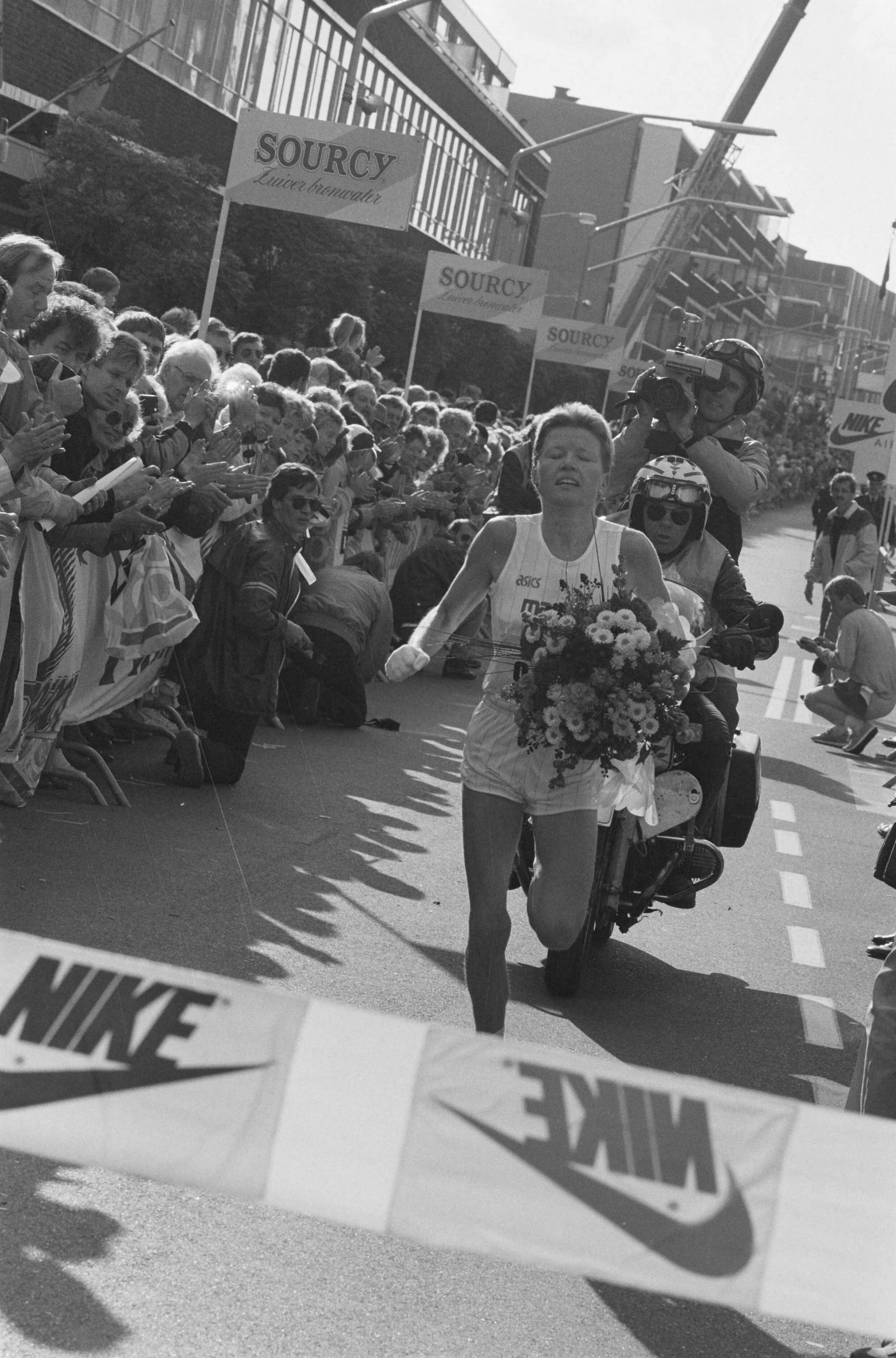 Fotocollectie Anefo — Dam tot dam-loop (16 km) finish in Zaandam; Ingrid Kristiansen gaat met bloemen over de finish — Foto: Bogaerts, Rob / Anefo. Licentie: Set B: Rechtenvrij / Publiek Domein. Bron: Nationaal Archief. http://hdl.handle.net/10648/ad64f554-d0b4-102d-bcf8-003048976d84