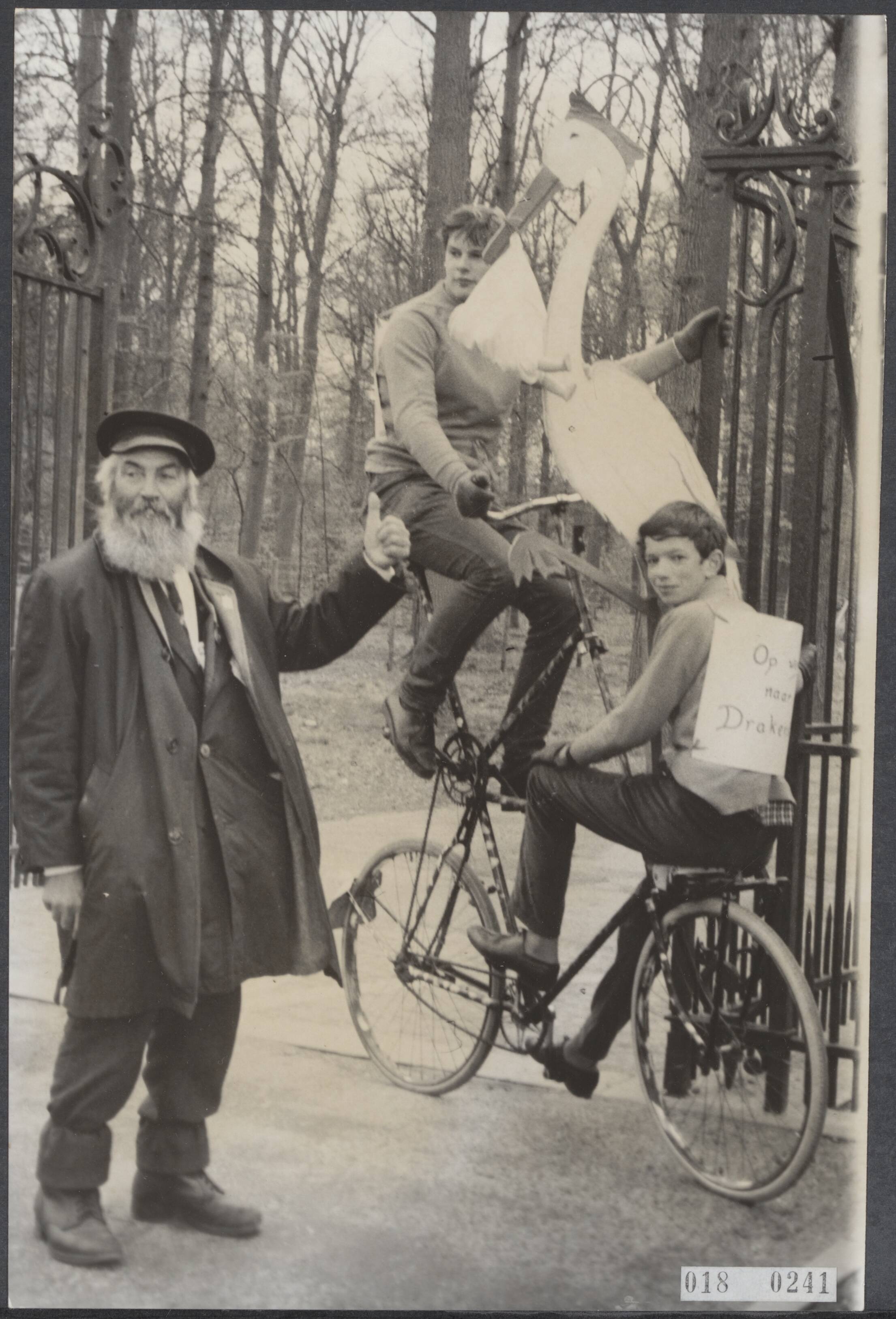 Fotocollectie Elsevier Binnenland — [Serie: drukte rond paleis Drakensteyn en in Lage Vuursche i.v.m. geboorte kroonprins] Vandaag was zowel de oude baas Bouwmeester voor het kasteelhek als ook twee jongens op een extra hoge fiets kompleet met ooievaar en baby afkomstig uit Ermelo — Foto: Fotograaf Onbekend / Anefo. Licentie: Set B: Rechtenvrij / Publiek Domein. Bron: Nationaal Archief. http://hdl.handle.net/10648/adc1a95c-d0b4-102d-bcf8-003048976d84