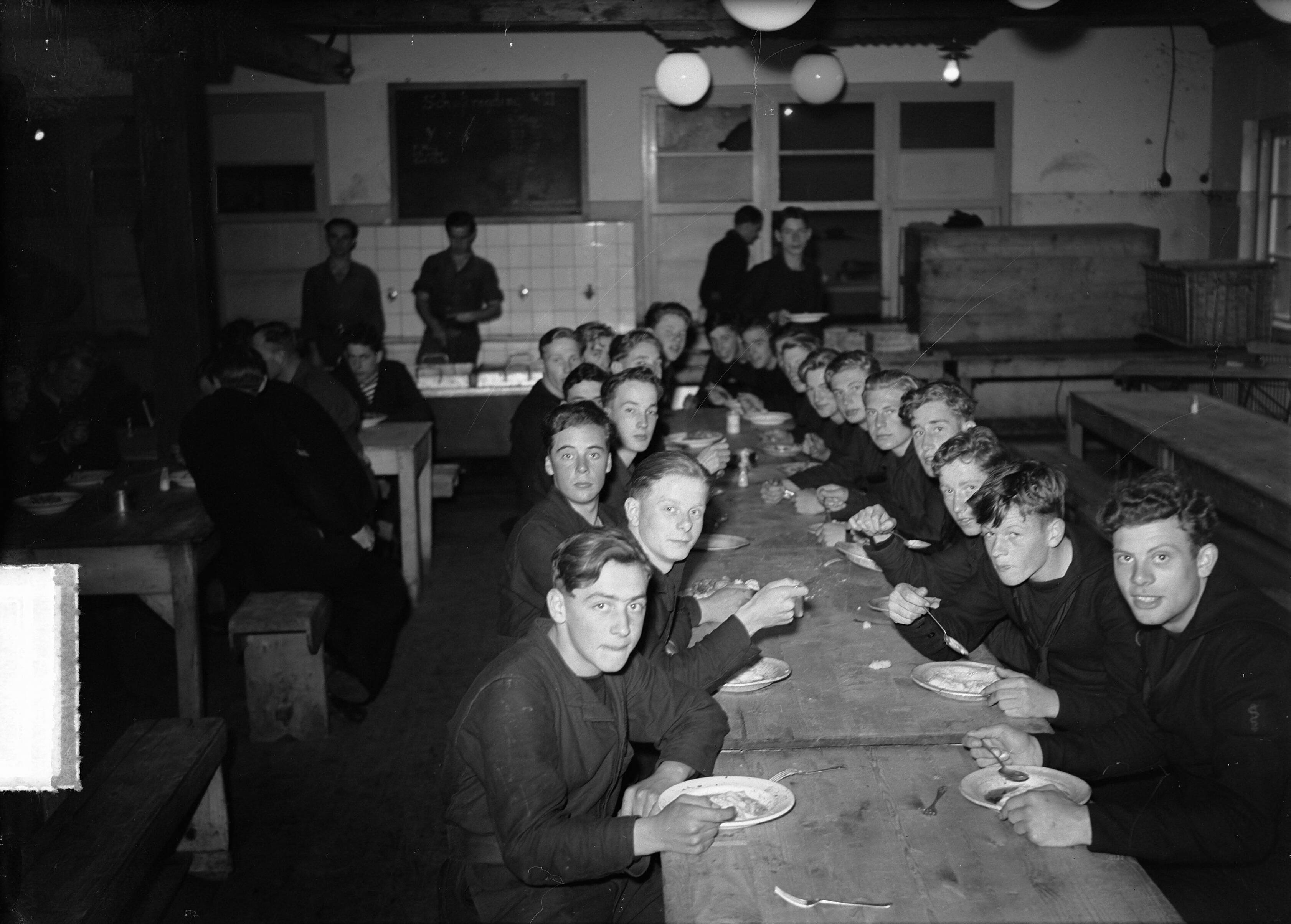 MOK Hilversum 1948 — MOK Hilversum. Matrozen aan het eten — Foto: Steenkamp, […] / Anefo. Licentie: Set B: Rechtenvrij / Publiek Domein. Bron: Nationaal Archief. http://hdl.handle.net/10648/a8bd9344-d0b4-102d-bcf8-003048976d84
