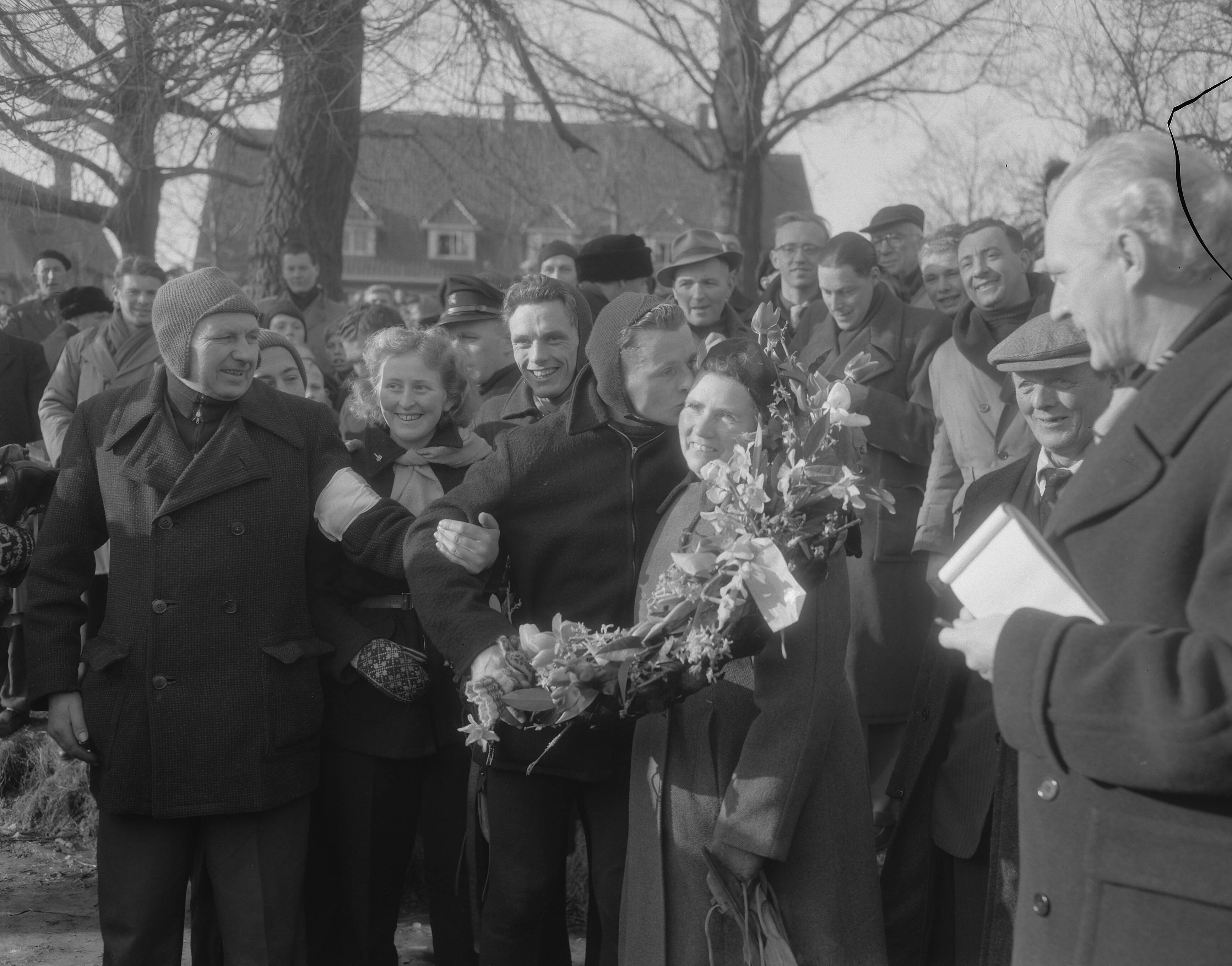 Elfstedentocht 1954 — Elfstedentocht. Jeen van den Berg gaat als eerste over de finish — Foto: Duinen, G.W. van / Anefo. Licentie: Set B: Rechtenvrij / Publiek Domein. Bron: Nationaal Archief. http://hdl.handle.net/10648/a91c68d8-d0b4-102d-bcf8-003048976d84