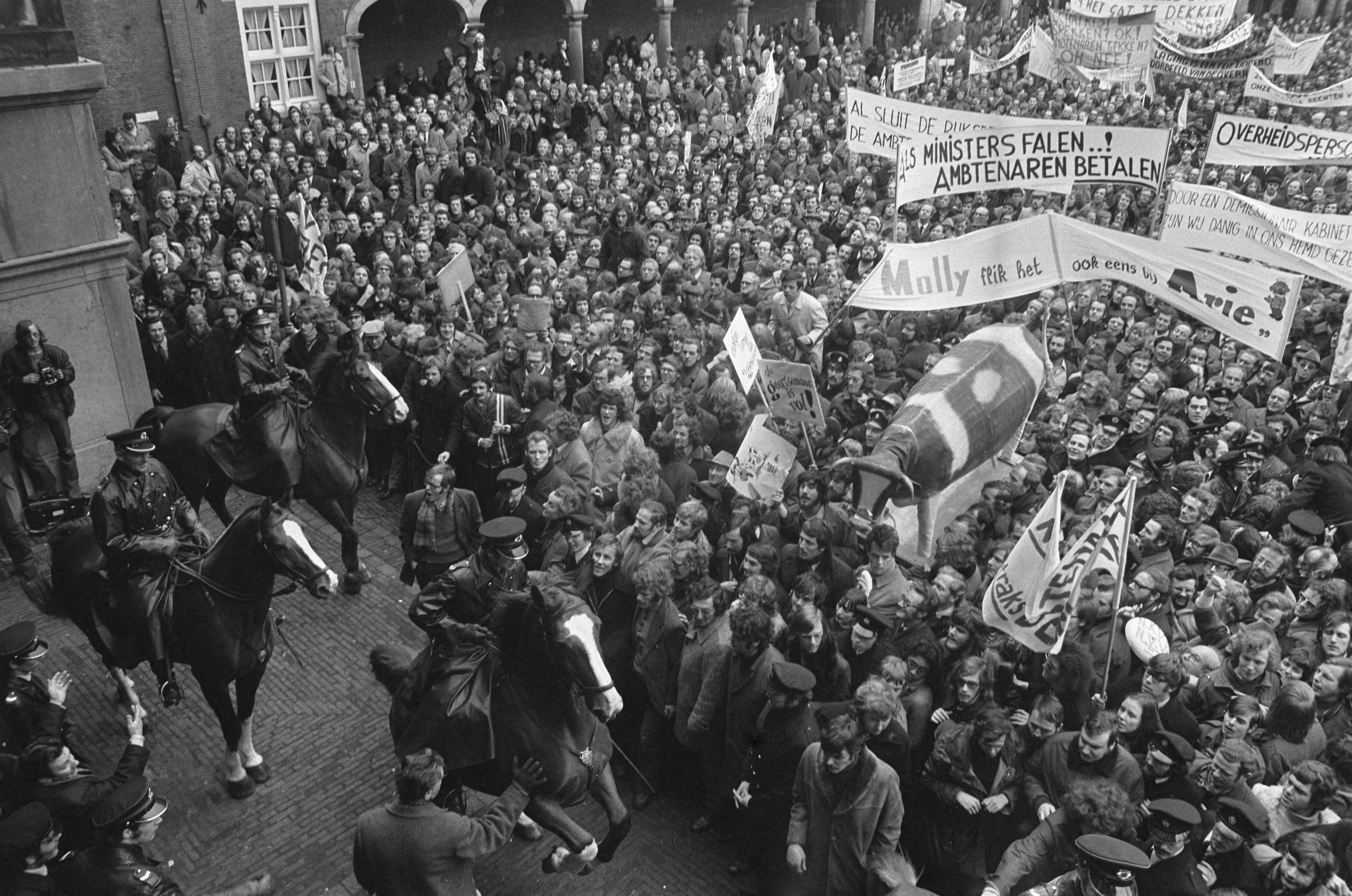 Fotocollectie Anefo — Ambtenaren (meer dan 40.000) demonstreren in Den Haag , de demonstranten op Binnenhof, met politie te paard — Foto: Peters, Hans / Anefo. Licentie: Set B: Rechtenvrij / Publiek Domein. Bron: Nationaal Archief. http://hdl.handle.net/10648/ac2450cc-d0b4-102d-bcf8-003048976d84