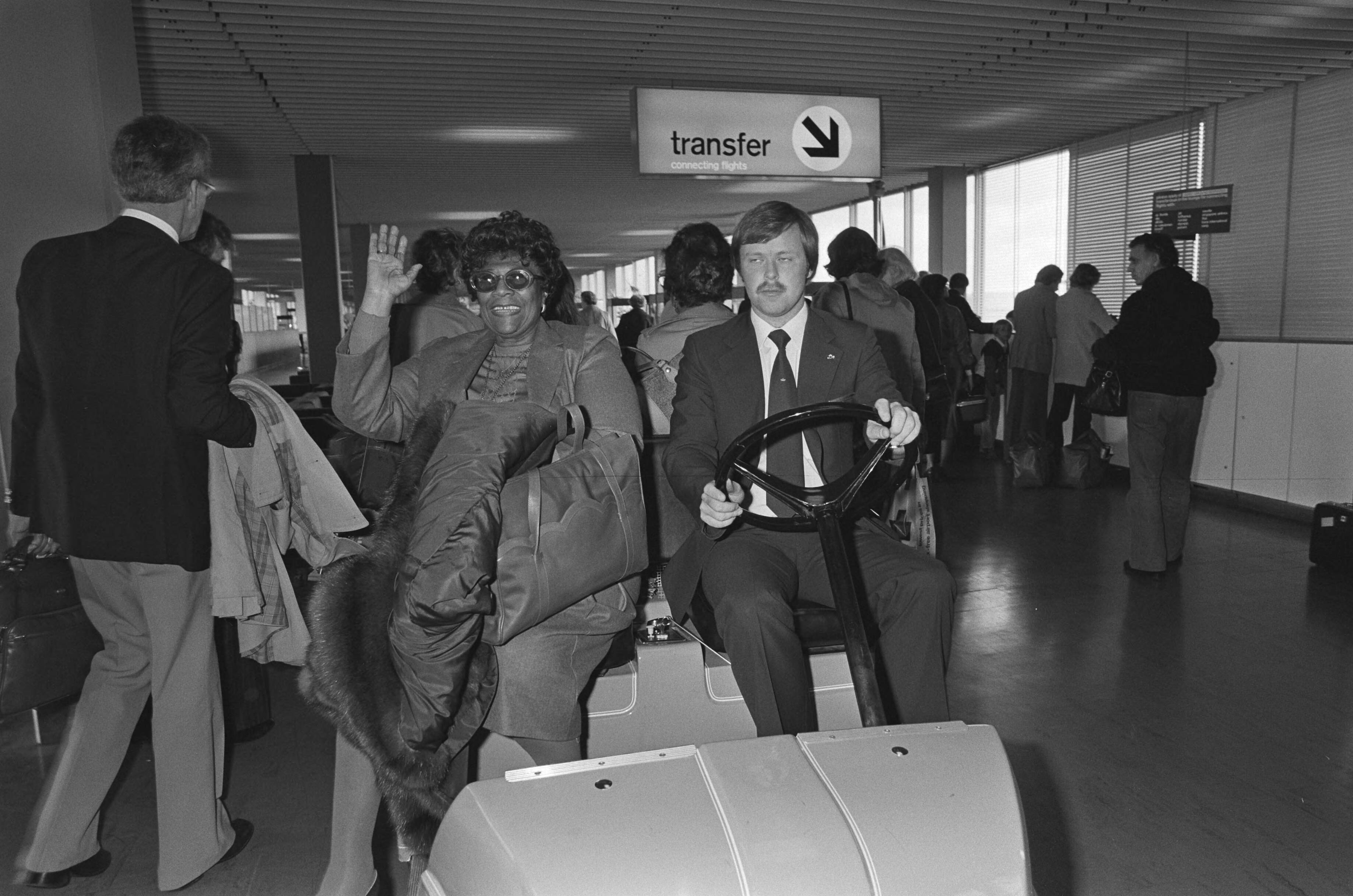 Fotocollectie Anefo — Jazz-zangeres Ella Fitzgerald uit VS in ons land voor concert in Amsterdam, Ella Fitzgerald tijdens aankomst Schiphol op speciaal karretje — Foto: Antonisse, Marcel / Anefo. Licentie: Set B: Rechtenvrij / Publiek Domein. Bron: Nationaal Archief. http://hdl.handle.net/10648/acec500e-d0b4-102d-bcf8-003048976d84