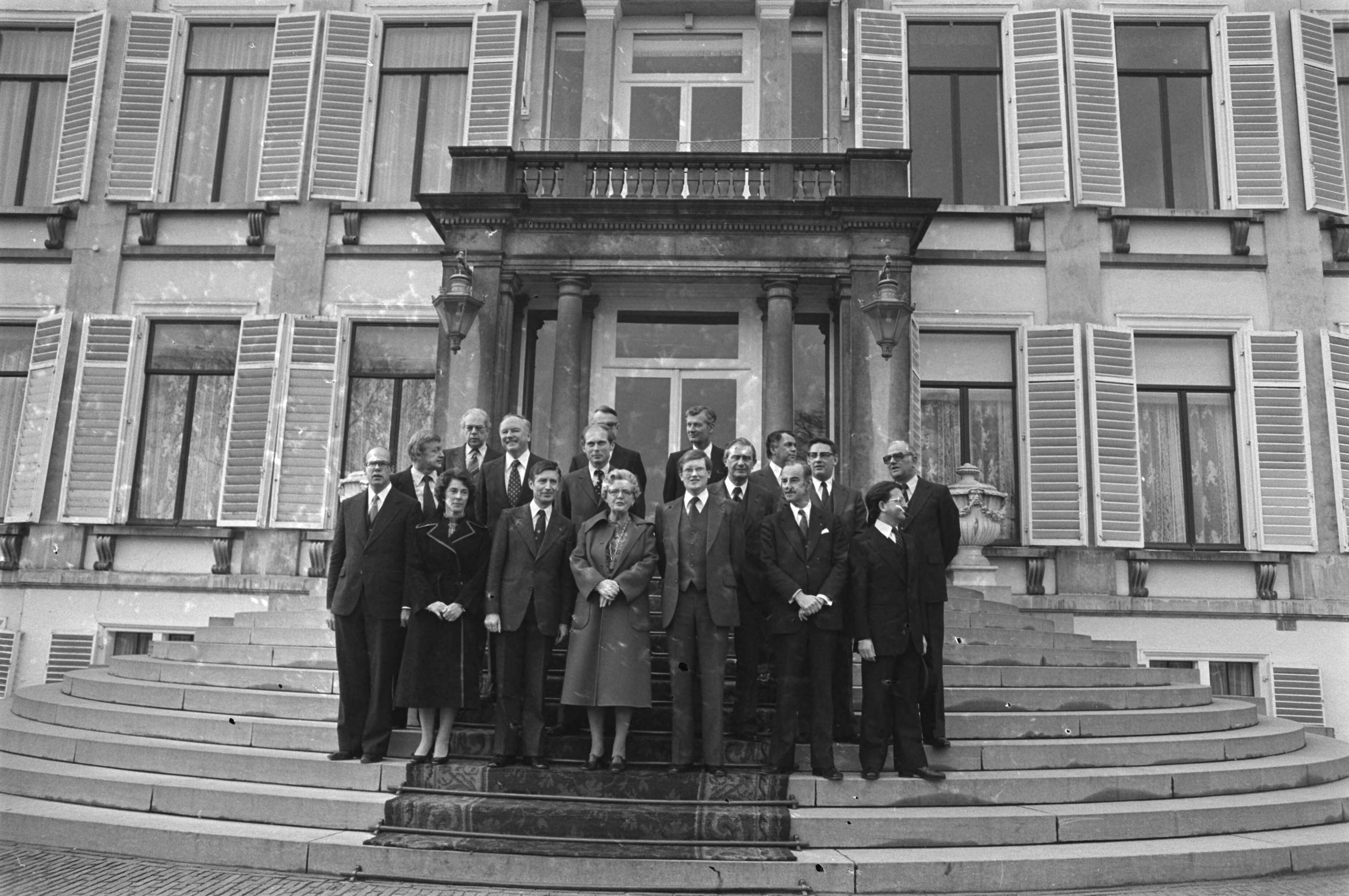 Fotocollectie Anefo — Beëdiging nieuw kabinet Van Agt op Soestdijk; voorste rij v.l.n.r. rij De Ruiter (Justitie), Gardeniers-Berendsen (Cultuur, Recreatie en Maatschappelijk Werk), Van Agt (minister-president, Algemene Zaken), koningin Juliana, Wiegel (Binnenlandse Zaken), Van der Klaauw (Buitenlandse Zaken), Pais (Onderwijs). 2e rij vlnr. Andriessen (Financiën), Kruisinga (Defensie), Beelaerts van Blokland (Volkshuisvesting en Ruimtelijke Ordening), Tuijnman (Verkeer en Waterstaat), Van Aardenne (Economische Zaken), Van der Stee (Landbouw en Visserij). 3e rij vlnr Albeda (Sociale Zaken), Ginjaar (Volksgezondheid en Milieu), De Koning (Ontwikkelingssamenwerking), Peijnenburg (Wetenschapsbeleid) — Foto: Verhoeff, Bert / Anefo. Licentie: Set B: Rechtenvrij / Publiek Domein. Bron: Nationaal Archief. http://hdl.handle.net/10648/aca884dc-d0b4-102d-bcf8-003048976d84