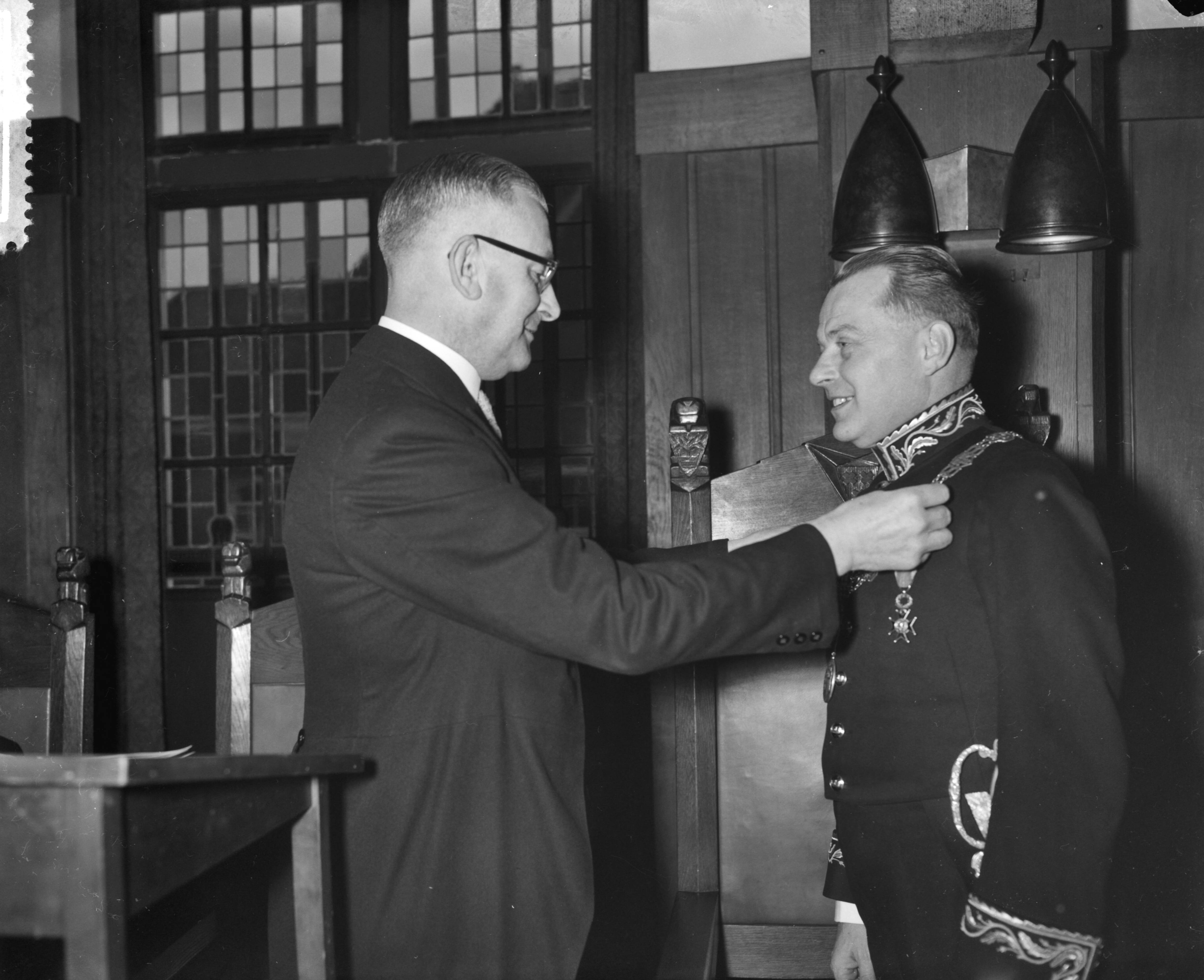 Fotocollectie Anefo — Installatie van mr. dr. R.M.A.A. Geuljans als burgemeester van Breda, loco-burgemeester J.A. Meijs hangt mr. dr. Geuljans de ambtsketen om — Foto: Bilsen, Joop van / Anefo. Licentie: Set B: Rechtenvrij / Publiek Domein. Bron: Nationaal Archief. http://hdl.handle.net/10648/a9a3eeca-d0b4-102d-bcf8-003048976d84