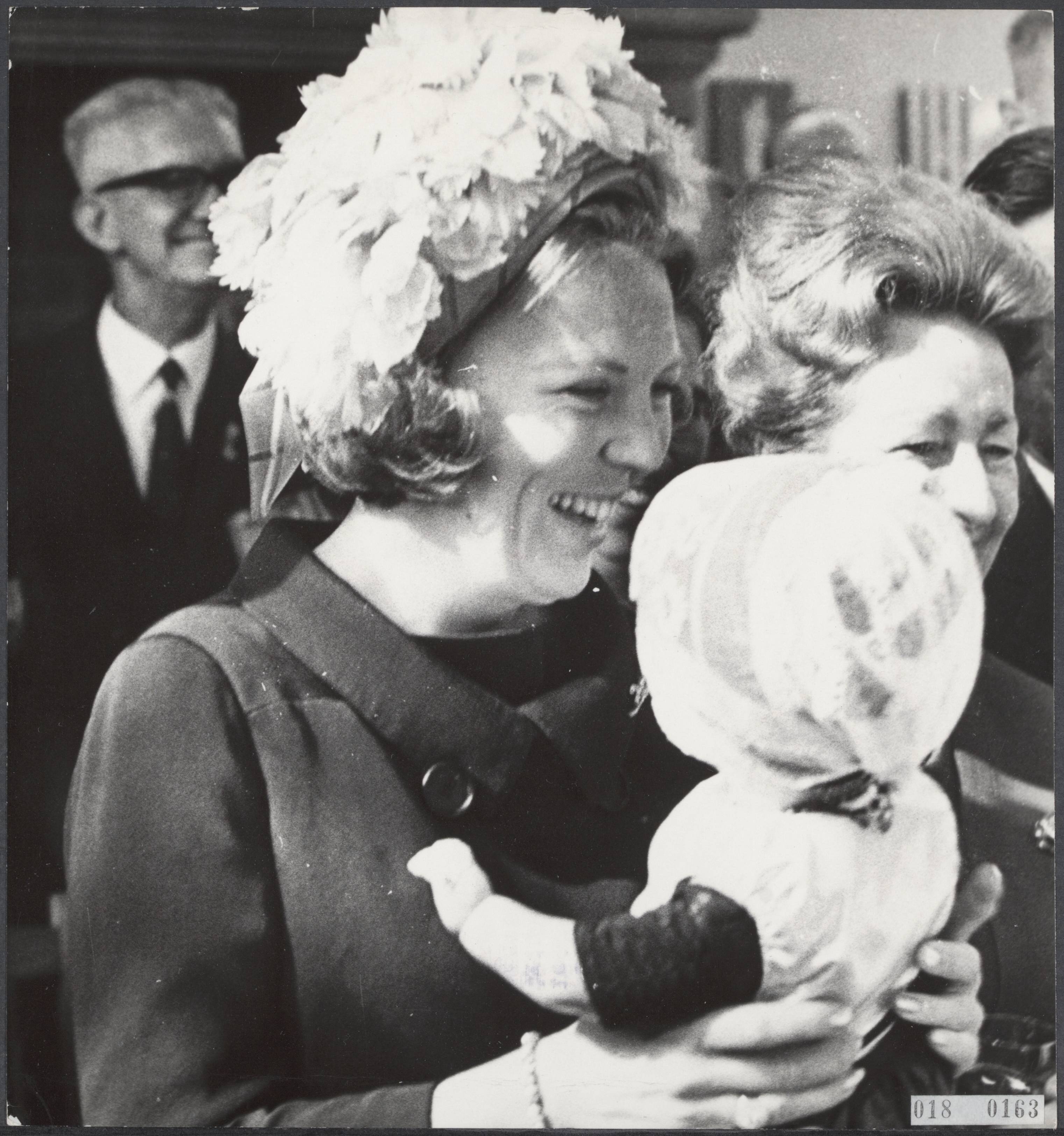 Fotocollectie Elsevier Binnenland — Ter gelegenheid van het jaarlijkse congres Veteranen Legioen Nederland te Middelburg heeft prinses Beatrix, in gezelschap van prins Claus, een krans gelegd bij het monument voor gevallenen uit de laatste wereldoorlog. Een Urker pop werd aangeboden aan de prinses door een congresdeelnemer — Foto: Merk, Ben / Anefo. Licentie: Set B: Rechtenvrij / Publiek Domein. Bron: Nationaal Archief. http://hdl.handle.net/10648/adc16910-d0b4-102d-bcf8-003048976d84