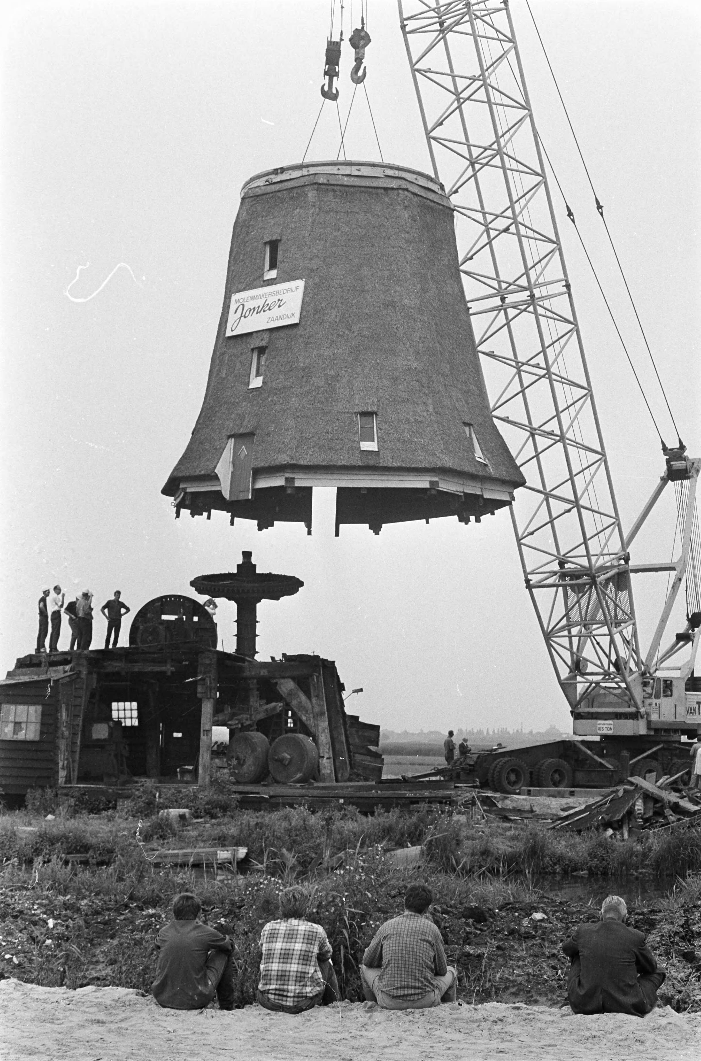 Verhuizing van de Zaanse oliemolen "de Zoeker" — De molen wordt door een kraan van het onderstuk gelicht — Foto: Fotograaf Onbekend / Anefo. Licentie: Set B: Rechtenvrij / Publiek Domein. Bron: Nationaal Archief. http://hdl.handle.net/10648/ab48c17e-d0b4-102d-bcf8-003048976d84