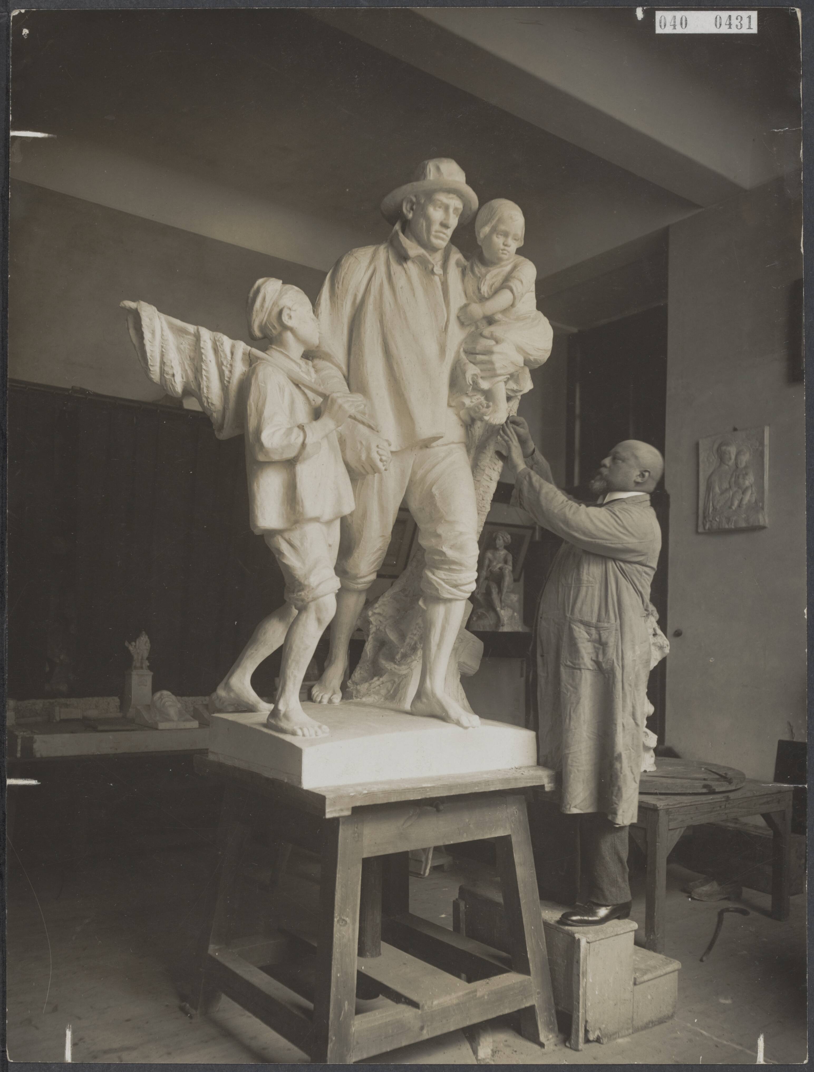 Fotocollectie Elsevier Binnenland — Beeldhouwer A. Hesselink bezig met het beeld getiteld "langs moeders graf", voorstellende een visser met zoon en dochter, naar een schilderij van Jozef Israëls. Het beeld zal in Groningen worden geplaatst — Foto: Fotopersbureau "Holland". Licentie: Set B: Rechtenvrij / Publiek Domein. Bron: Nationaal Archief. http://hdl.handle.net/10648/adf44bc8-d0b4-102d-bcf8-003048976d84