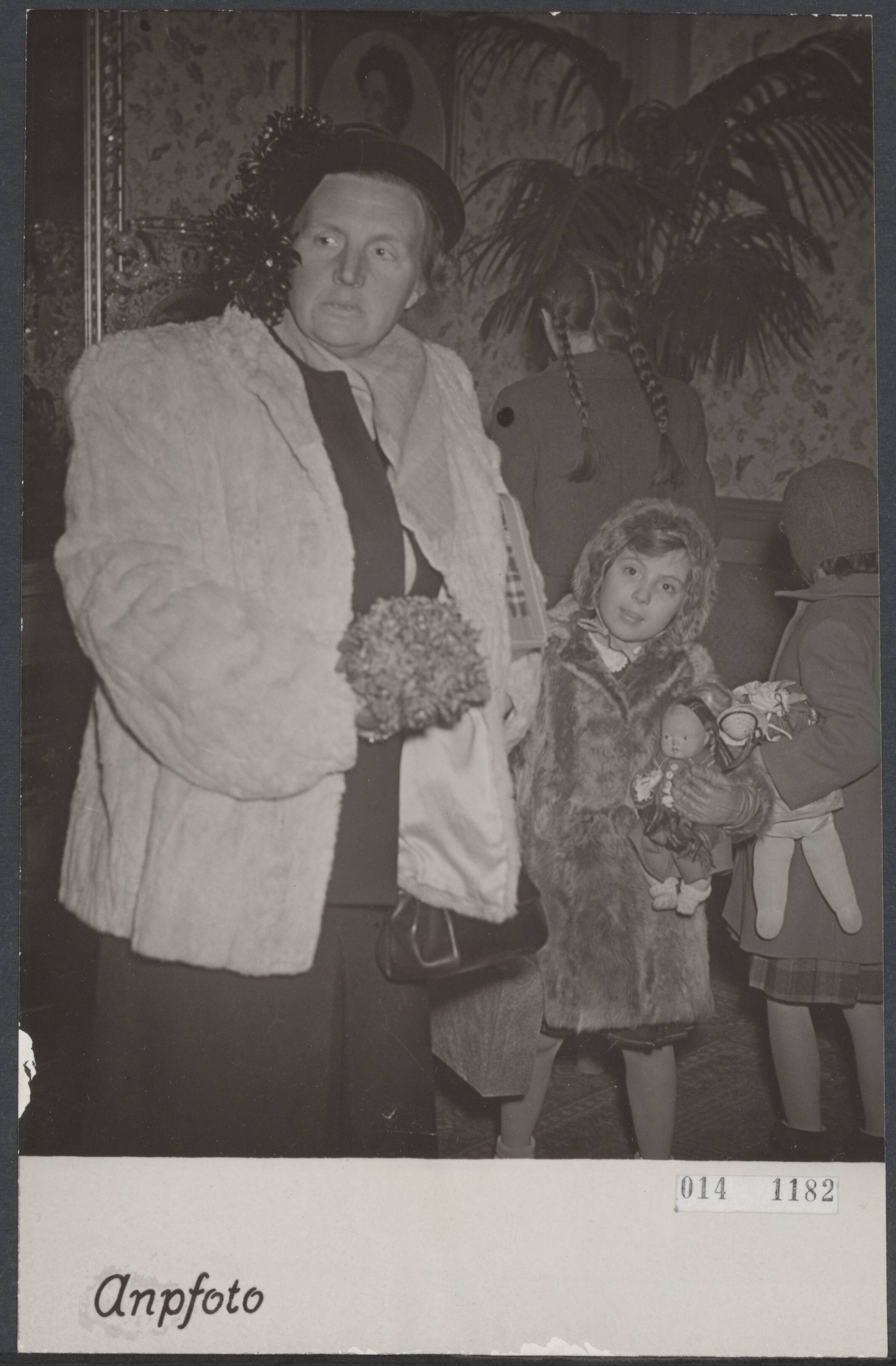 Fotocollectie Elsevier Binnenland — Dinsdagavond zijn koningin Juliana en de prinsesjes Beatrix, Irene en Margriet uit Sankt Anton in Nederland teruggekeerd. De koningin en prinses Margreit in de wachtkamer van het station te Baarn. In haar arm heeft prinses Margriet de pop in Oostenrijkse klederdracht, welke bij het vertrek uit Sankt Anton werd aangeboden — Foto: ANP / RVD of rechtenvrij. Licentie: Set B: Rechtenvrij / Publiek Domein. Bron: Nationaal Archief. http://hdl.handle.net/10648/adb30078-d0b4-102d-bcf8-003048976d84