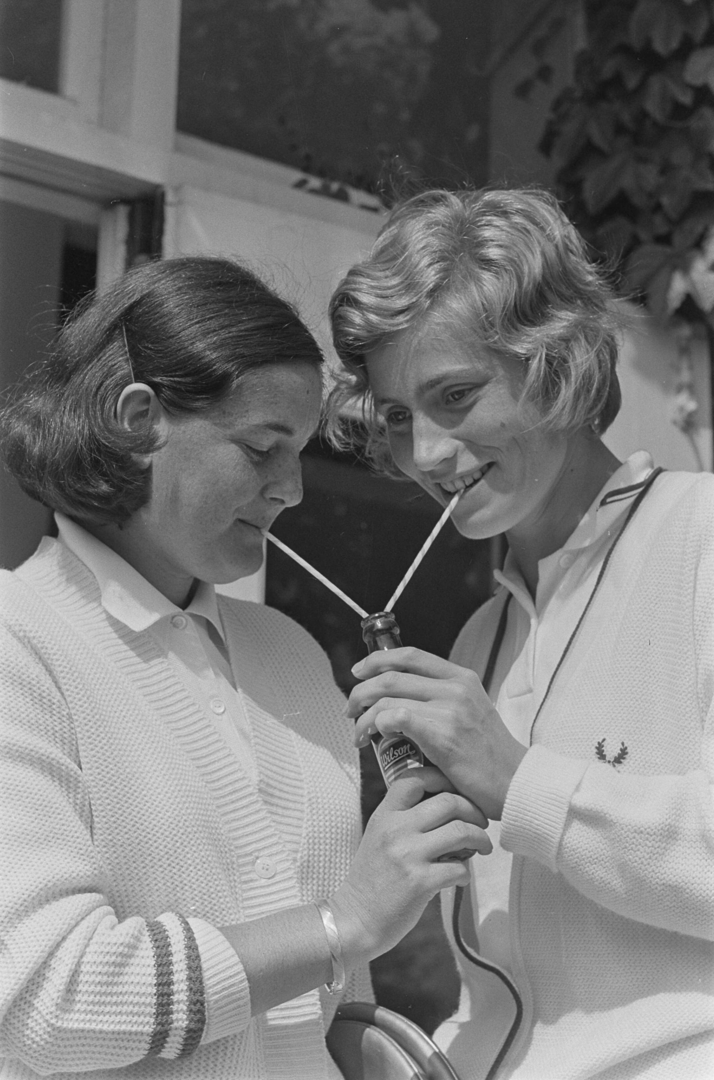 Fotocollectie Anefo — Nederlandse tenniskampioenschappen op de METS-banen te Scheveningen. Els Spruyt (links) en Trudy Groenman drinken met twee rietjes uit 1 flesje limonade — Foto: Koch, Eric / Anefo. Licentie: Set B: Rechtenvrij / Publiek Domein. Bron: Nationaal Archief. http://hdl.handle.net/10648/aaba68ac-d0b4-102d-bcf8-003048976d84