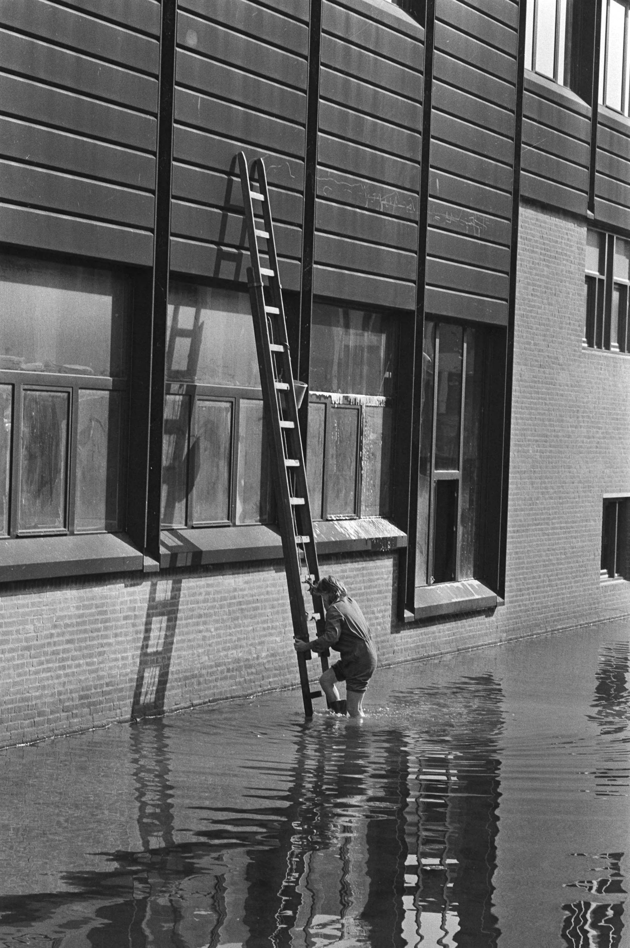 Glazenwasser met ladder in het water van het winkelcentrum in Almere Haven — Almere|Flevoland|glazenwassers |winkelcentra — Foto: Suyk, Koen / Anefo. Licentie: Set B: Rechtenvrij / Publiek Domein. Bron: Nationaal Archief. http://hdl.handle.net/10648/acd0a552-d0b4-102d-bcf8-003048976d84
