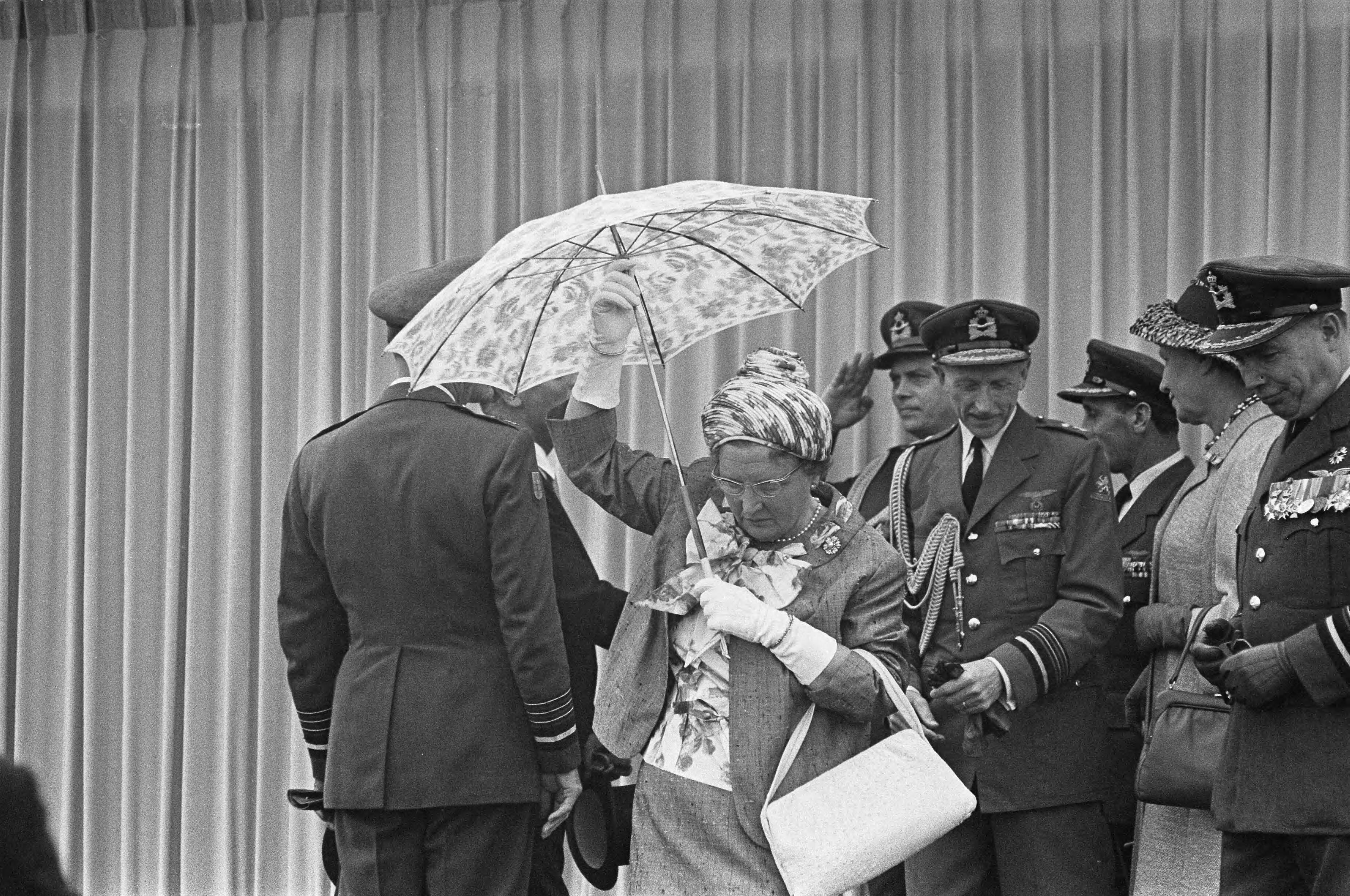 Fotocollectie Anefo — Vijftig jaar Koninklijke Luchtmacht. Defilé op Soesterberg. Koningin Juliana steekt een paraplu op, rechts generaals Heije Schaper, chef van het Militaire Huis van de koningin en H.P. Zielstra, commandant luchtstrijdkrachten — Foto: Koch, Eric / Anefo. Licentie: Set B: Rechtenvrij / Publiek Domein. Bron: Nationaal Archief. http://hdl.handle.net/10648/aa3d358a-d0b4-102d-bcf8-003048976d84