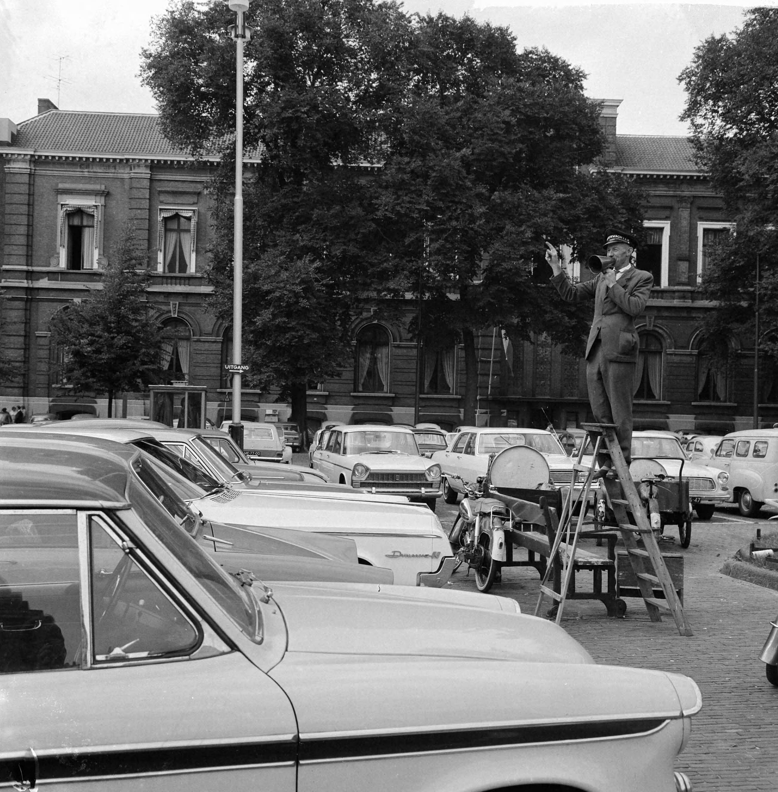 Fotocollectie Anefo — Autobewaker op Binnenhof te Den Haag geeft aanwijzingen op trap met behulp van scheepstoeter — Foto: Nijs, Jac. de / Anefo. Licentie: Set B: Rechtenvrij / Publiek Domein. Bron: Nationaal Archief. http://hdl.handle.net/10648/aa7923f6-d0b4-102d-bcf8-003048976d84
