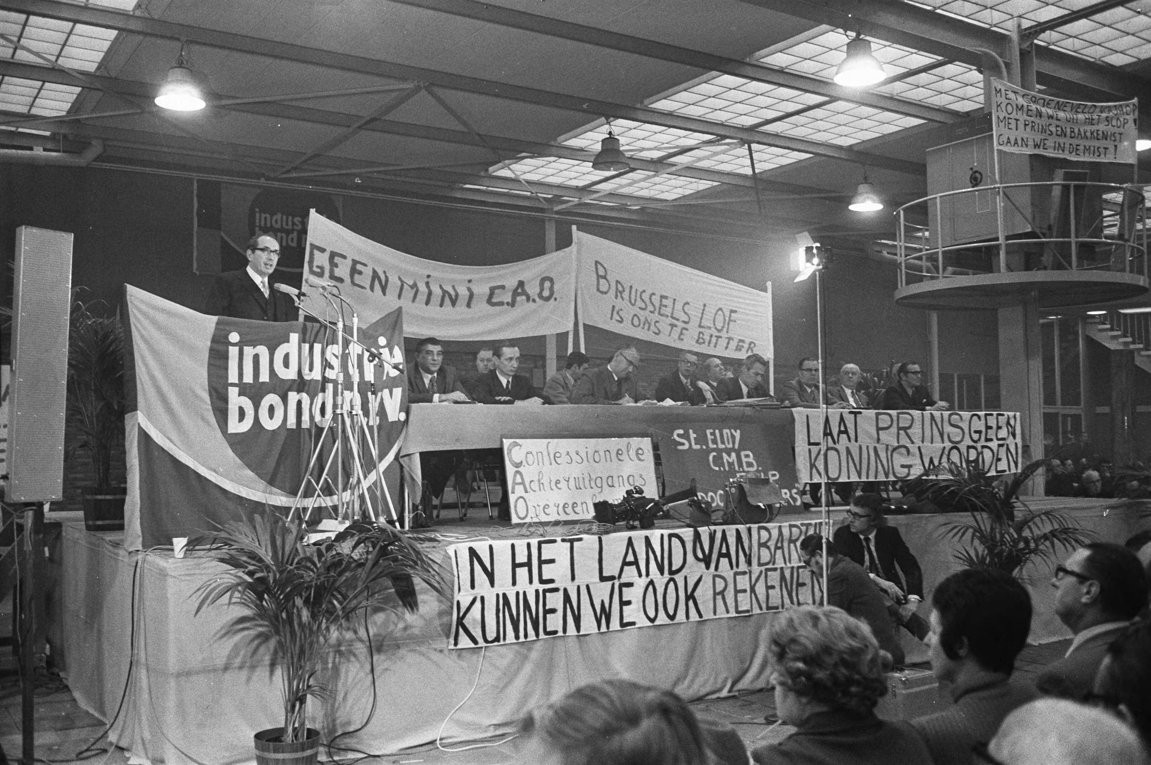 Fotocollectie Anefo — Kadervergadering van Industriebond van NVV in Merwedehotel Utrecht, (l) heer Groenevelt (voorzitter Industriebond NVV naast hem bestuurstafel met spandoeken / — Foto: Peters, Hans / Anefo. Licentie: Set B: Rechtenvrij / Publiek Domein. Bron: Nationaal Archief. http://hdl.handle.net/10648/abde1d5a-d0b4-102d-bcf8-003048976d84