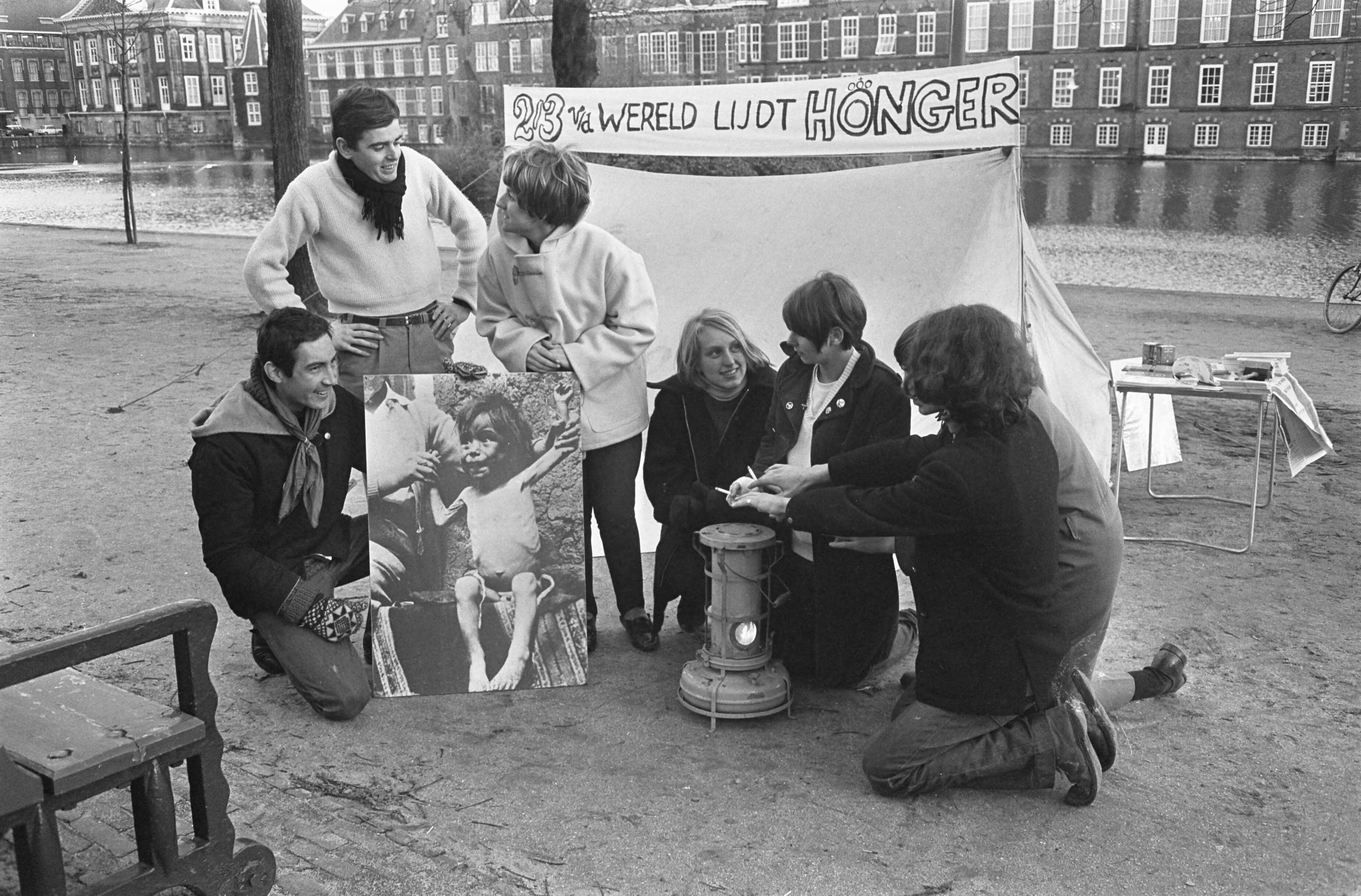 Fotocollectie Anefo — Honger Aktie van jongeren op de Lange Vijverberg in Den Haag , demonstranten met oliekacheltje — Foto: Koch, Eric / Anefo. Licentie: Set B: Rechtenvrij / Publiek Domein. Bron: Nationaal Archief. http://hdl.handle.net/10648/ab307650-d0b4-102d-bcf8-003048976d84