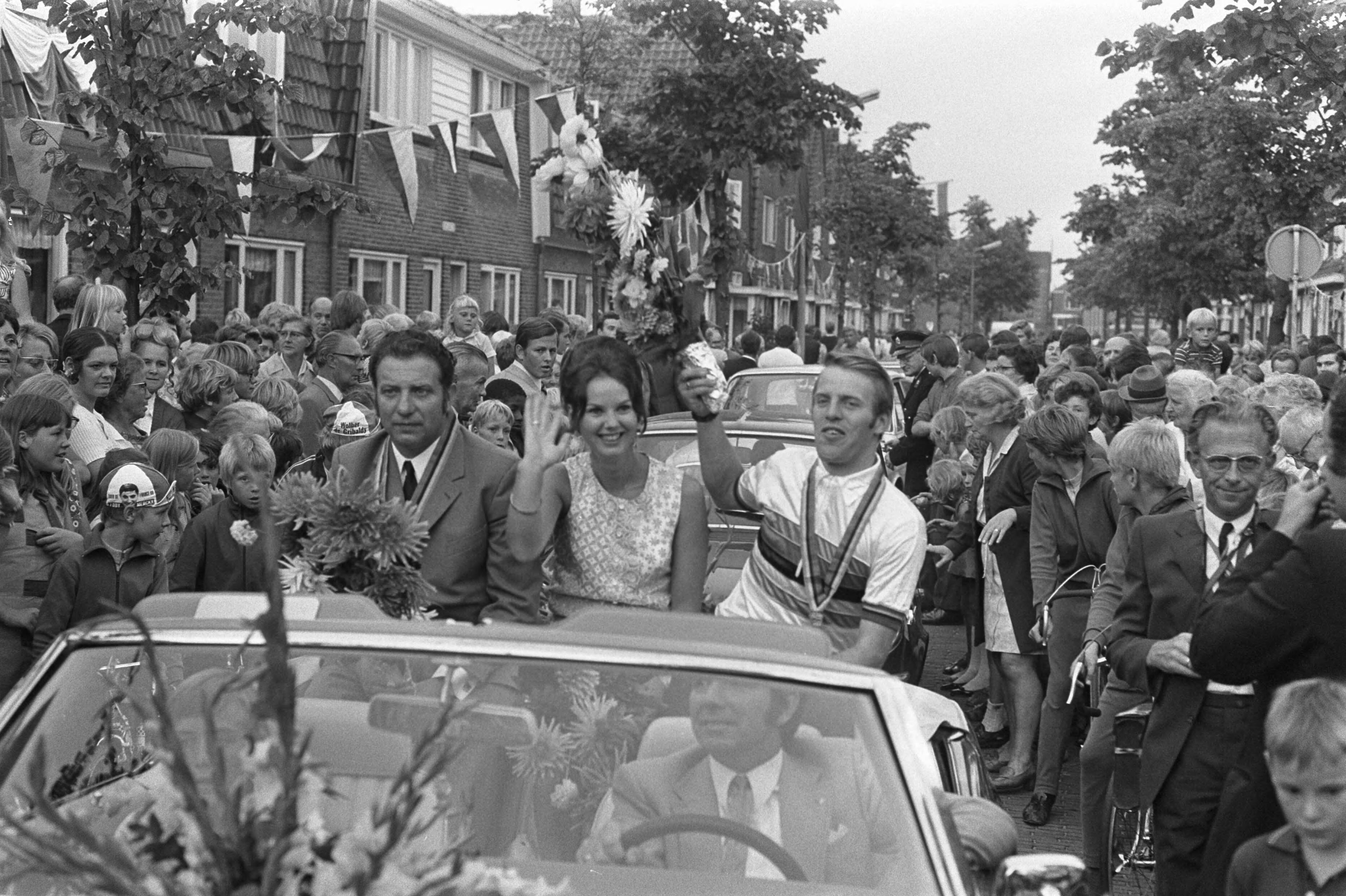 Fotocollectie Anefo — Wielrenner Cees Stam wordt gehuldigd in Koog aan de Zaan ; gangmaker Stakenburg en Stam en echtgenote in auto in het dorp — Foto: Verhoeff, Bert / Anefo. Licentie: Set B: Rechtenvrij / Publiek Domein. Bron: Nationaal Archief. http://hdl.handle.net/10648/ab9f78f2-d0b4-102d-bcf8-003048976d84
