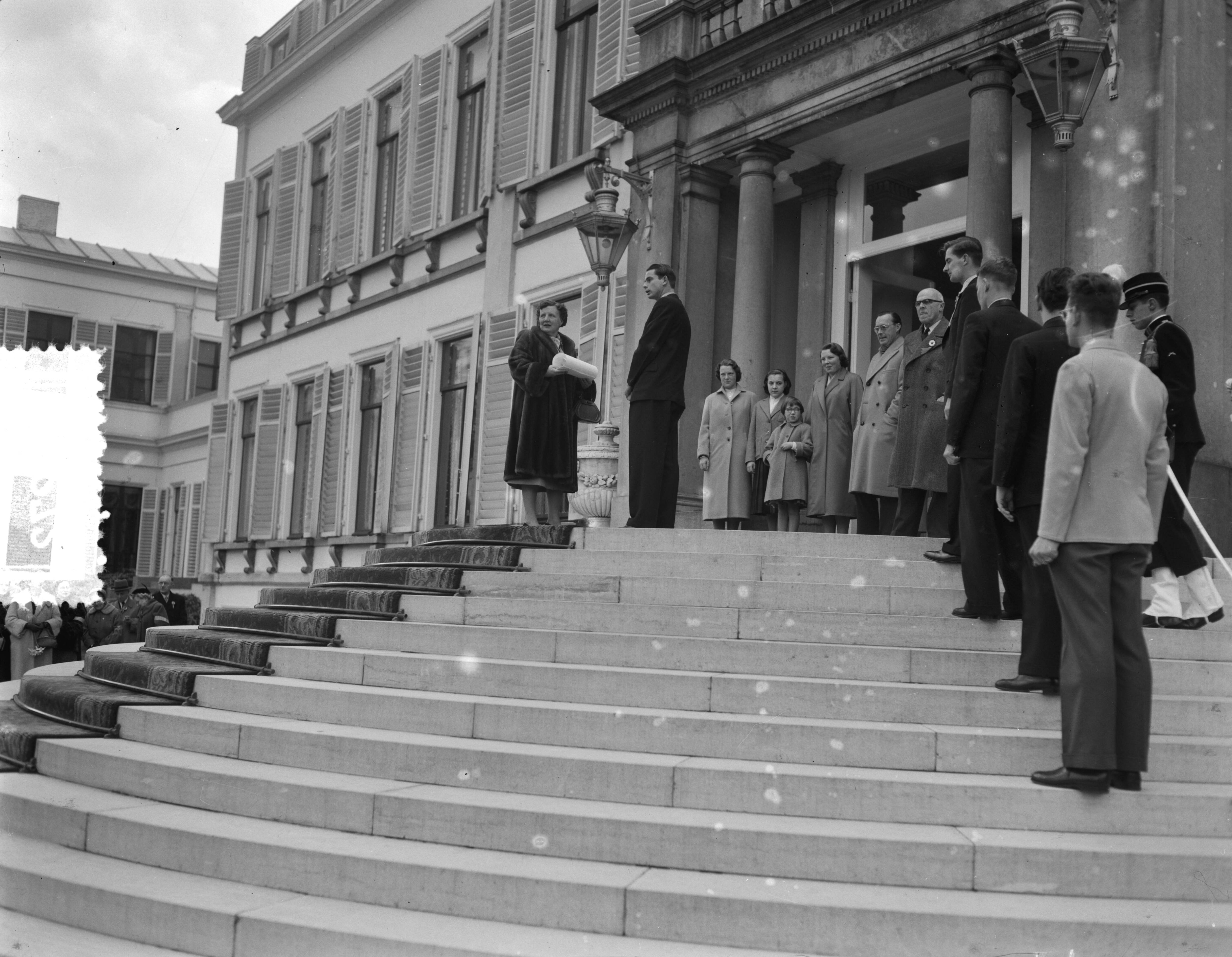 Koninginnedag 1956 — Defilé langs de koninklijke familie op het bordes van paleis Soestdijk; koningin Juliana krijgt een cadeau aangeboden — Foto: Noske, J.D. / Anefo. Licentie: Set B: Rechtenvrij / Publiek Domein. Bron: Nationaal Archief. http://hdl.handle.net/10648/a94708e0-d0b4-102d-bcf8-003048976d84