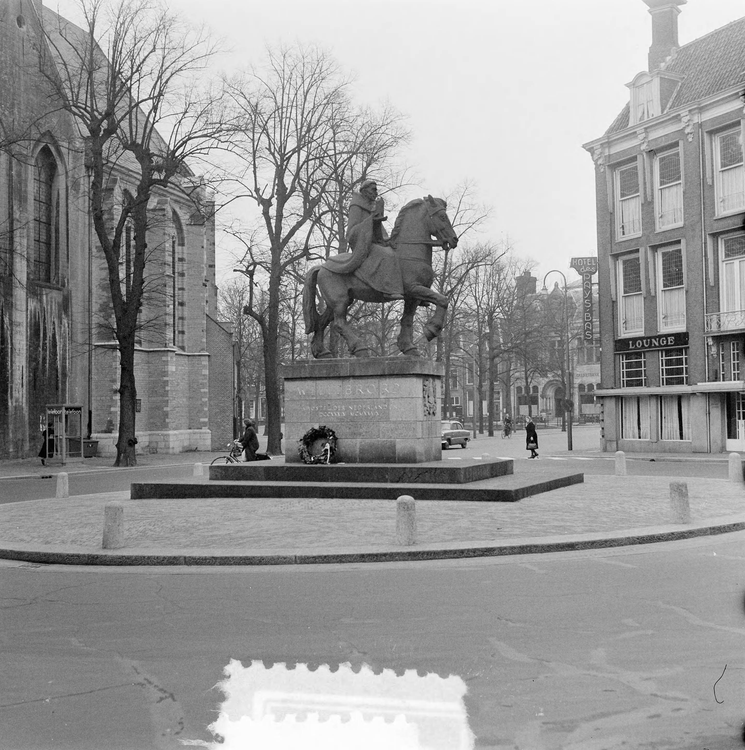 Stadsgezichten Utrecht — Stadsgezichten Utrecht. Standbeeld van Willibrord aan de Lange Jansstraat - Korte Jansstraat - Janskerkhof. Links de Janskerk — Foto: Noske, J.D. / Anefo. Licentie: Set B: Rechtenvrij / Publiek Domein. Bron: Nationaal Archief. http://hdl.handle.net/10648/a91b79be-d0b4-102d-bcf8-003048976d84