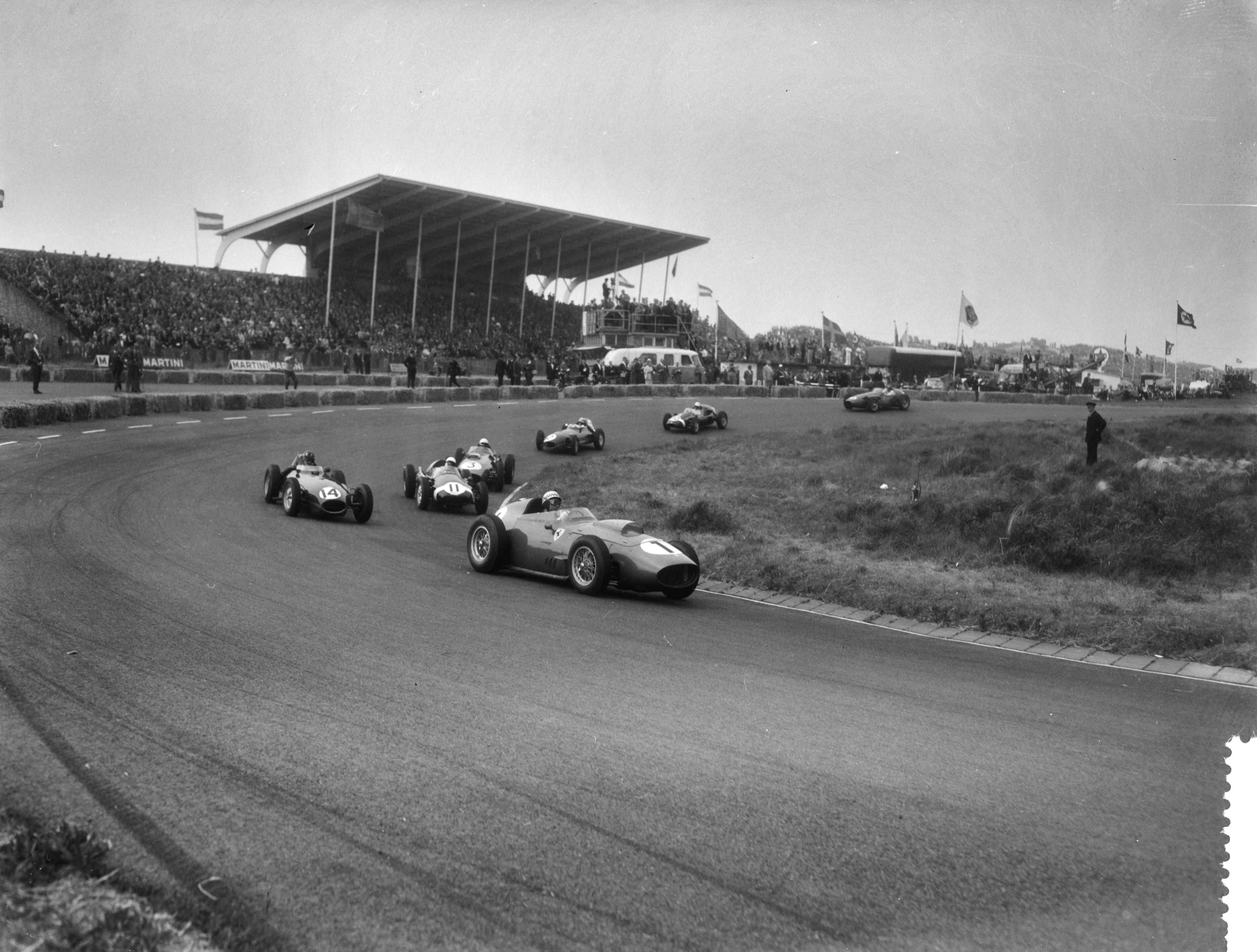 Grand Prix Zandvoort 1959 — Grand Prix van Nederland op het circuit van Zandvoort, op kop Jean Berhra in een Ferra Dino, gevolgd door Graham Hill (Lotus) en Stirling Moss (Coopers) — Foto: Pot, Harry / Anefo. Licentie: Set B: Rechtenvrij / Publiek Domein. Bron: Nationaal Archief. http://hdl.handle.net/10648/a995334e-d0b4-102d-bcf8-003048976d84