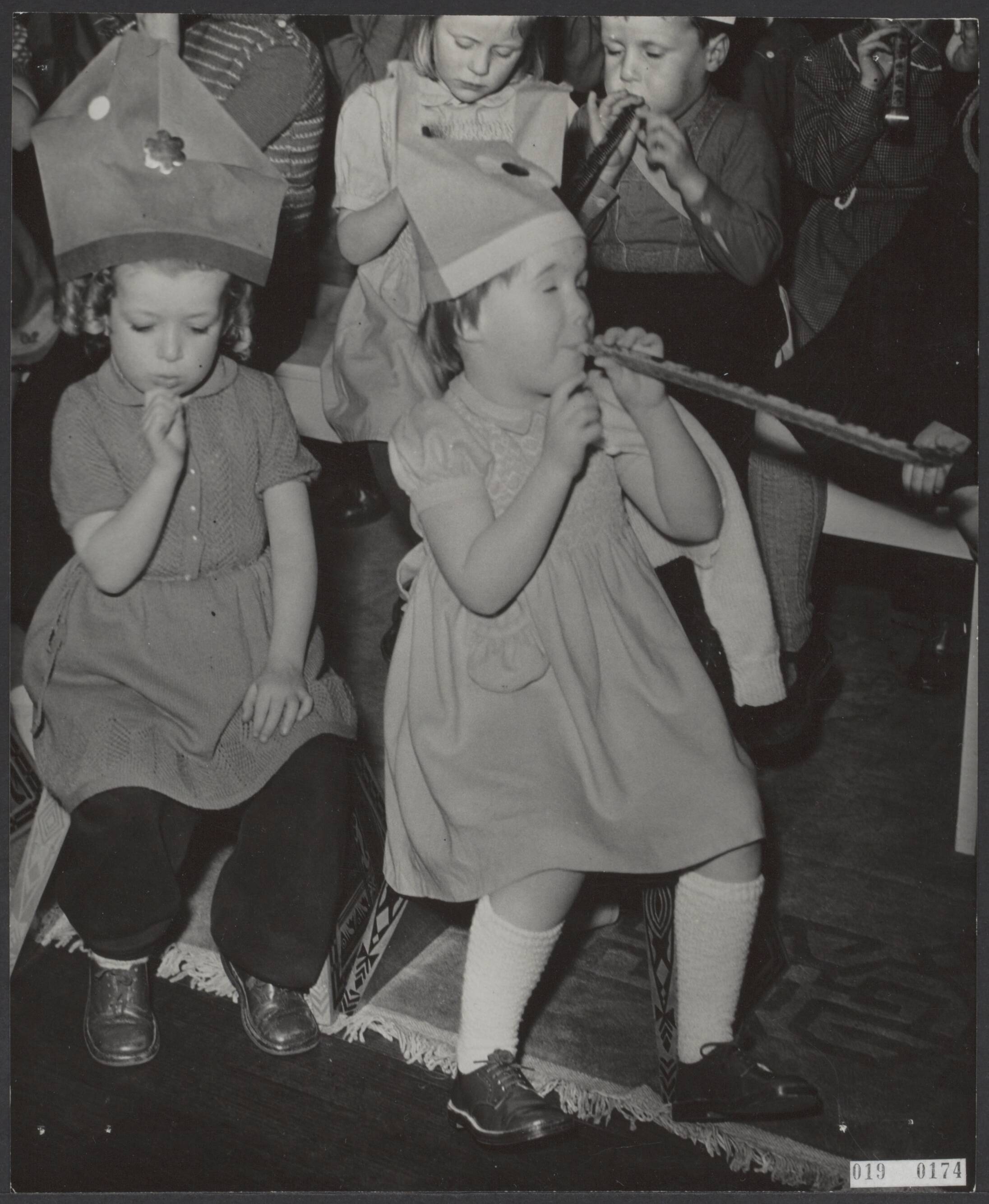 Fotocollectie Elsevier Binnenland — Bijeenkomst voor geevacueerde kinderen op paleis Soestdijk. De feesttoeters ontbraken niet op het feest. Links een evacuee en rechts prinses Marijke (Christina) — Foto: Fotograaf Onbekend / Anefo. Licentie: Set B: Rechtenvrij / Publiek Domein. Bron: Nationaal Archief. http://hdl.handle.net/10648/adc5b8ee-d0b4-102d-bcf8-003048976d84
