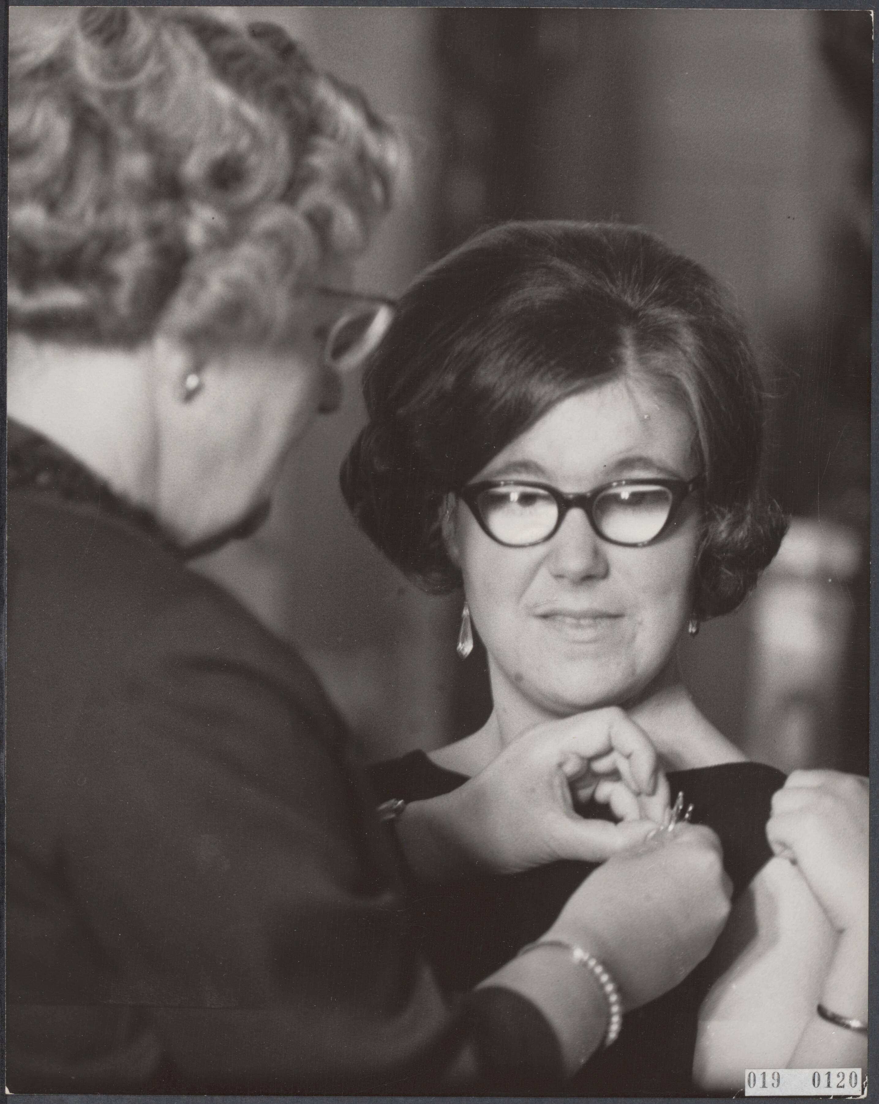 Fotocollectie Elsevier Binnenland — Prinses Christina kreeg op paleis Soestdijk een gouden broche met briljanten van de landmacht afd. Verbindingsdienst. Koningin Juliana hielp een handje bij het opspelden van de broche — Foto: Nijs, Jac. de / Anefo. Licentie: Set B: Rechtenvrij / Publiek Domein. Bron: Nationaal Archief. http://hdl.handle.net/10648/adc59044-d0b4-102d-bcf8-003048976d84