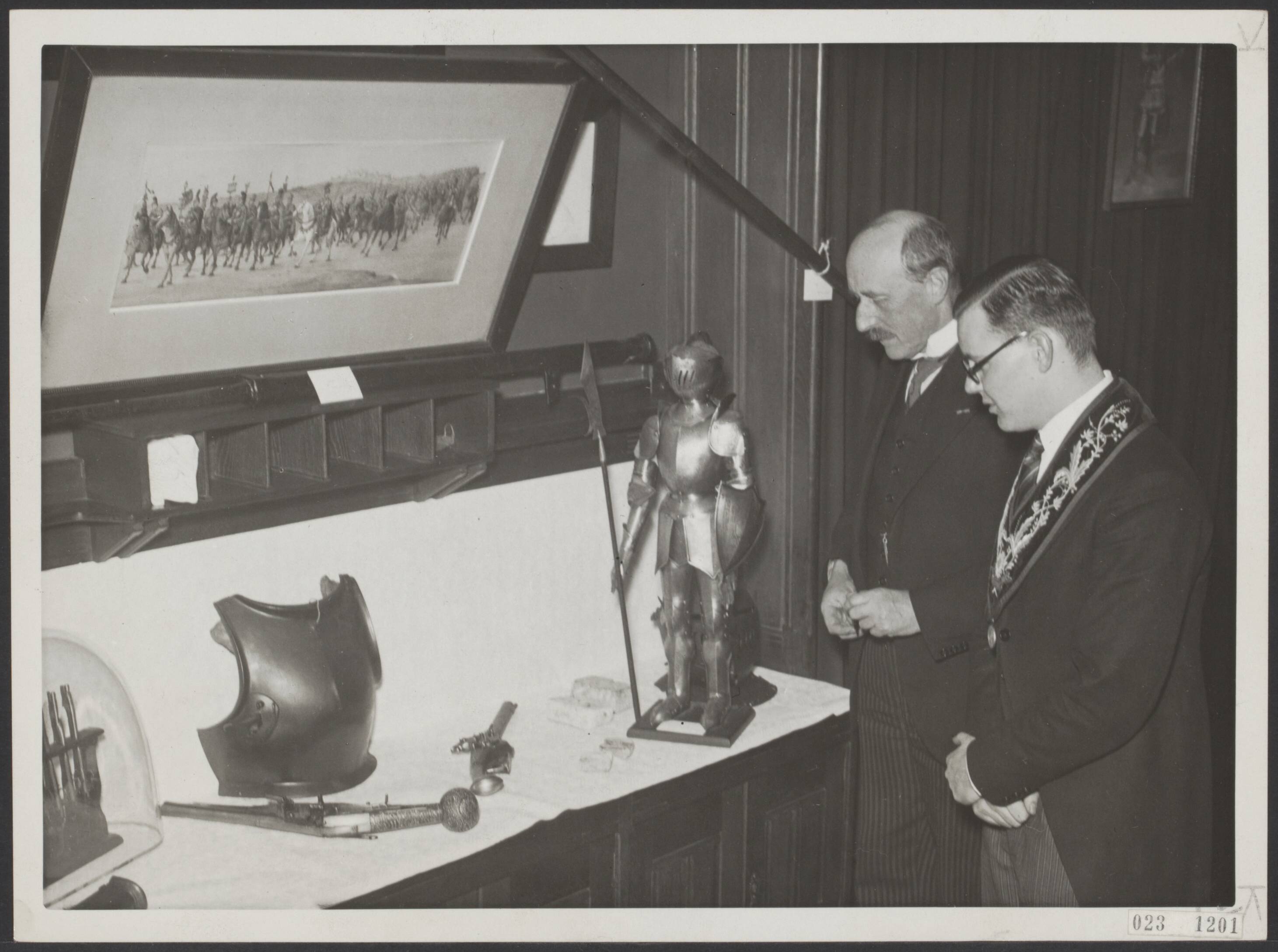 Fotocollectie Elsevier Binnenland — Lustrumviering van het USC (Utrechts Studenten Corps). Door de rector veteranorum werd in de leeszaal boven de sociëteit P.H.R.M. een tentoonstelling geopend van voorwerpen en tekeningen, betrekking hebbend op de tijd waarin het, ter gelegenheid van de lustrumfeesten tot viering van het 300-jarig bestaan van de universiteit , op te voeren openluchtspel "De Groote Geus" speelt. Bij de afdeling oude gebruiksvoorwerpen, tijdens de rondgang. Links de rector magnificus prof. dr. C.W. Vollgraff en rechts de rector veteranorum P.N. Drost — Foto: N.V. Polygoon. Licentie: Set B: Rechtenvrij / Publiek Domein. Bron: Nationaal Archief. http://hdl.handle.net/10648/add64bd2-d0b4-102d-bcf8-003048976d84