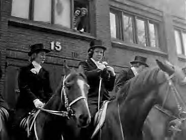 12e lustrum Utrechtse Vrouwelijke Studenten Vereniging (UVSV). Prinses Margriet rijdt als amazone mee in de stoet — Begin 12e lustrum van de Utrechtse Vrouwelijke Studenten Vereniging (UVSV). Prinses Irene rijdt mee als amazone in de stoet. Zij speldt een bloem als corsage op — Foto: Bilsen, Joop van / Anefo. Licentie: Set B: Rechtenvrij / Publiek Domein. Bron: Nationaal Archief. http://hdl.handle.net/10648/a9923126-d0b4-102d-bcf8-003048976d84