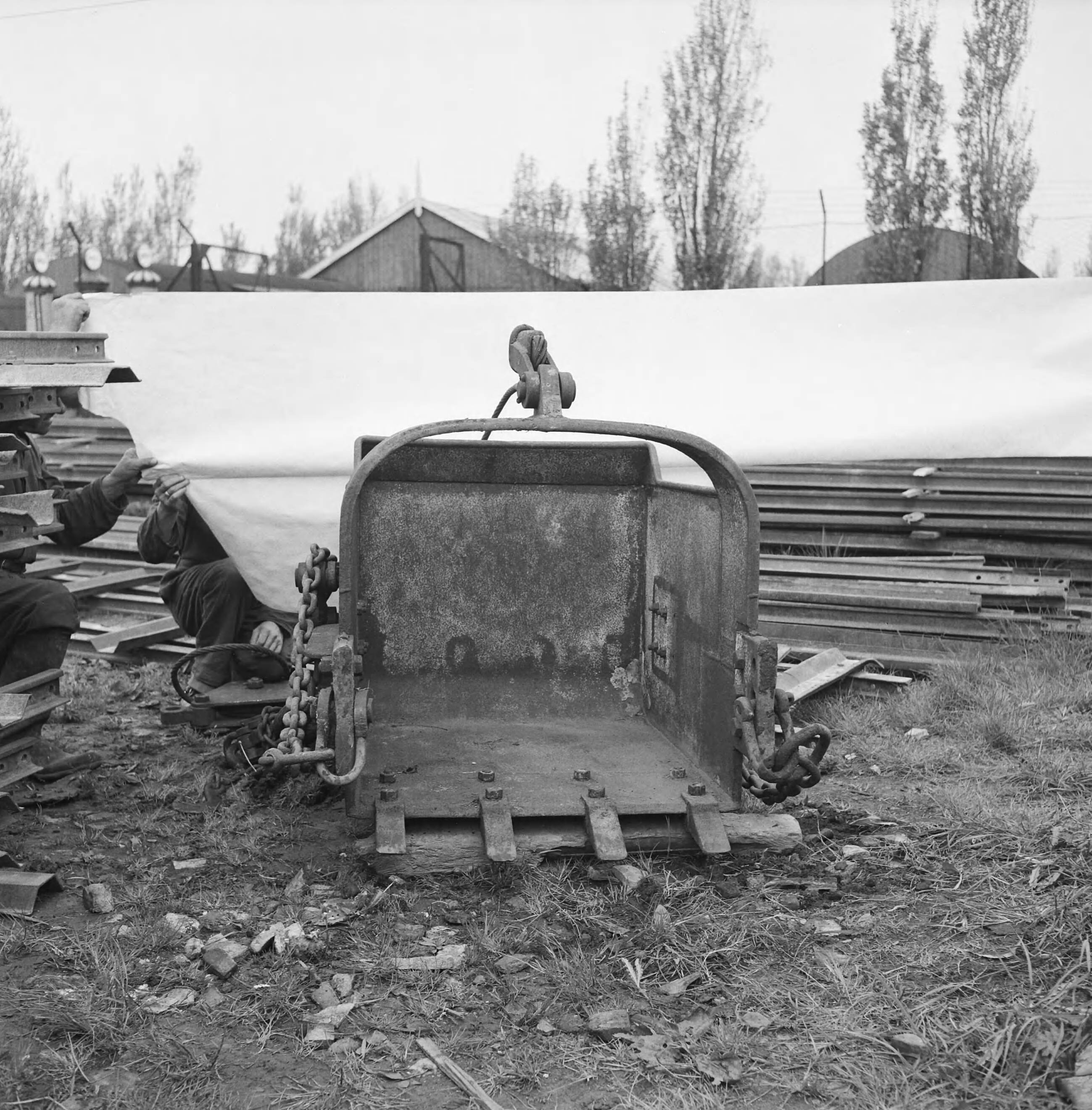 Fotocollectie Nederlandse Heidemaatschappij — Draglinebak opslagplaats N.H.M. Middelburg, inhoud 700 liter. — Foto: Fotograaf Onbekend / Heidemij. Licentie: Set B: Rechtenvrij / Publiek Domein. Bron: Nationaal Archief. http://hdl.handle.net/10648/ae6e6b38-d0b4-102d-bcf8-003048976d84