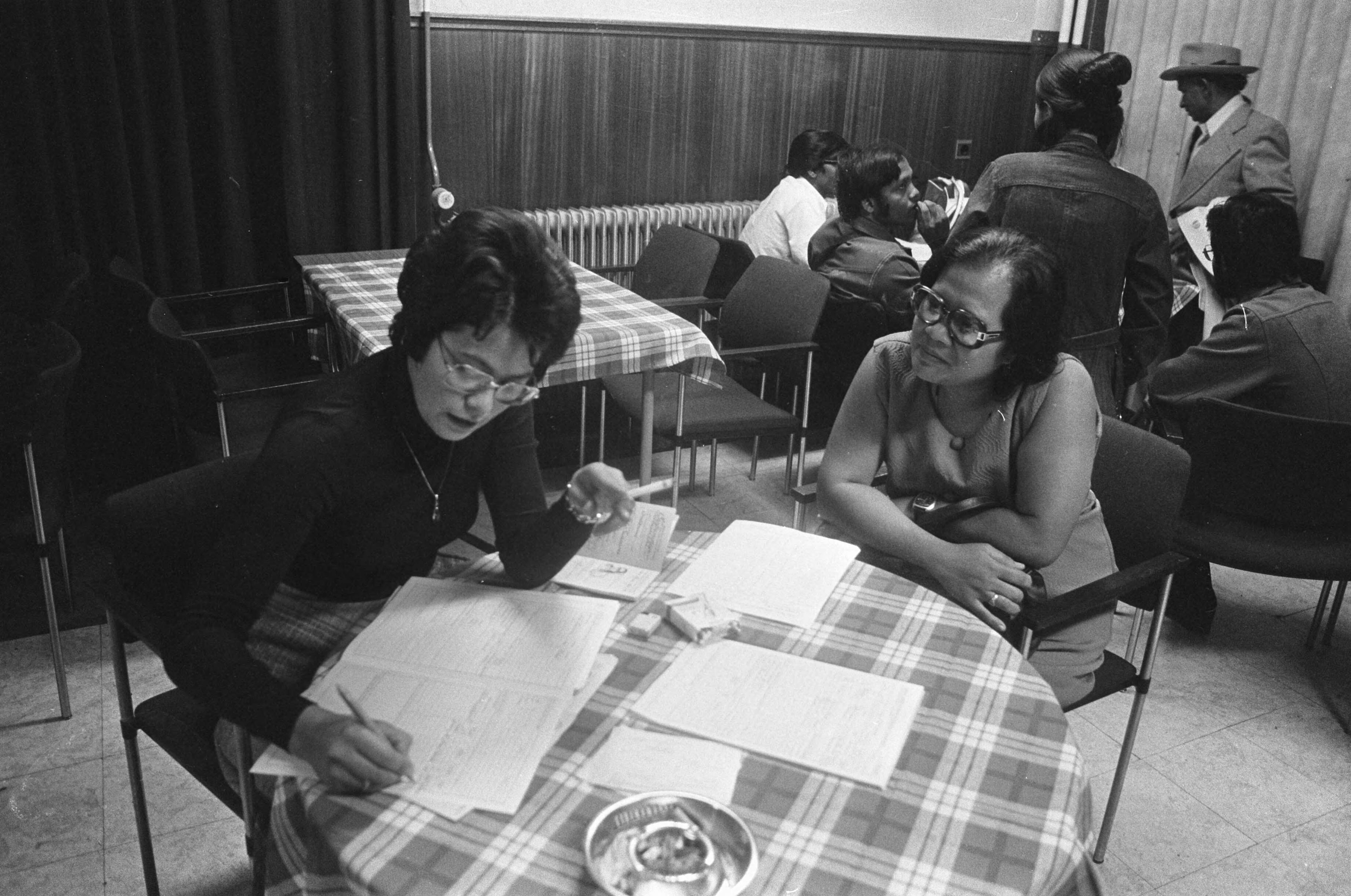 Fotocollectie Anefo — Aankomst Surinamers op vliegveld Schiphol en opvang in het Witte Huis te Soest; Surinaamse laat zich registreren bij ambtenares — Foto: Peters, Hans / Anefo. Licentie: Set B: Rechtenvrij / Publiek Domein. Bron: Nationaal Archief. http://hdl.handle.net/10648/ac719346-d0b4-102d-bcf8-003048976d84