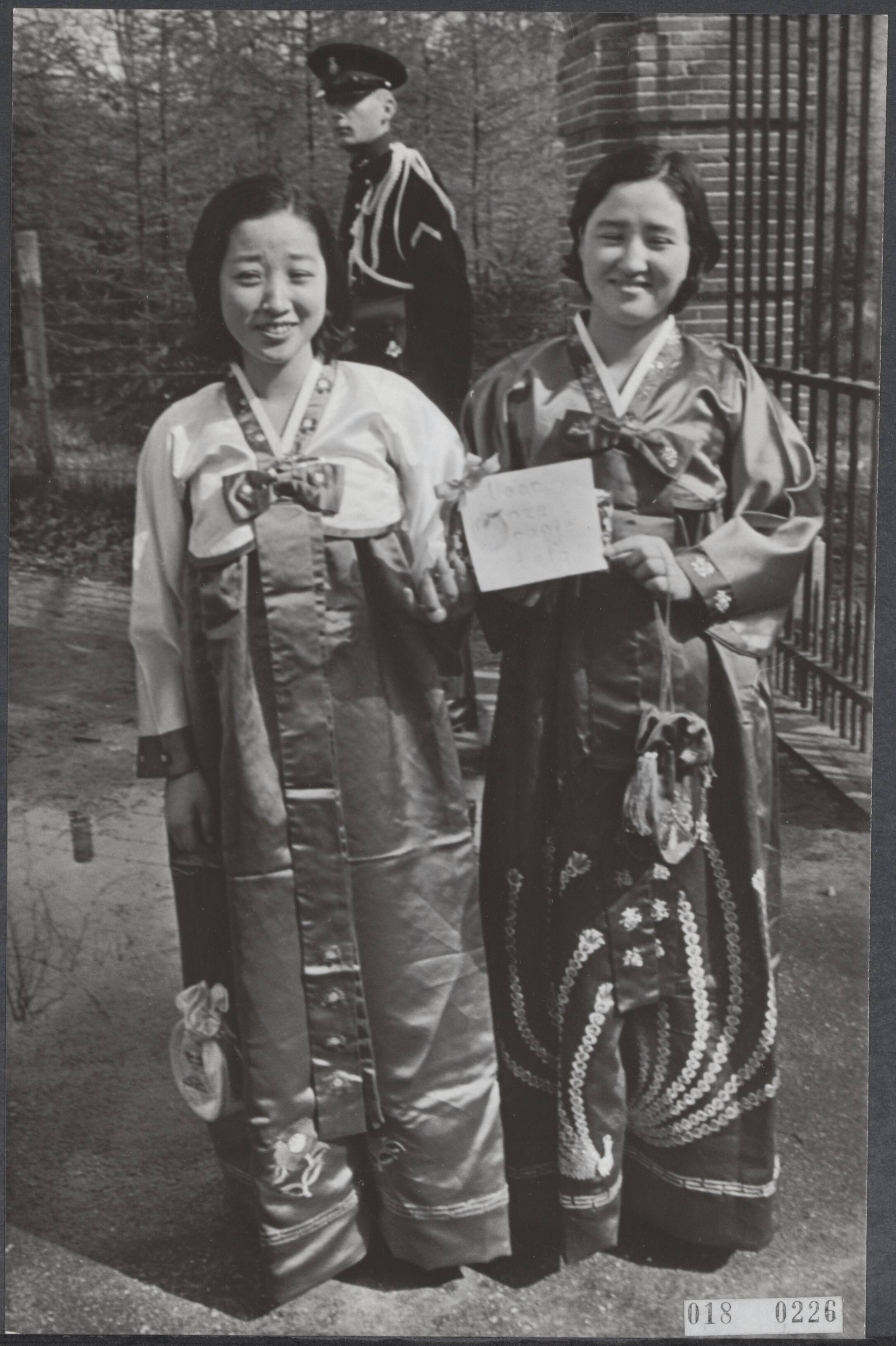 Fotocollectie Elsevier Binnenland — Twee meisjes uit Korea kwamen bij de hekken van kasteel Drakensteyn met een pakje waarin zelfgemaakte sokjes voor de komende Oranjetelg. Djun Ja Kim en Djun Suk Kim werken sinds 3 jaar in het gereformeerde bejaardencentrum "d'Amandelboom" te Bilthoven. Een telefoontje via de Marechaussee naar het paleisje was genoeg om even later binnen te mogen — Foto: Fotograaf Onbekend / Anefo. Licentie: Set B: Rechtenvrij / Publiek Domein. Bron: Nationaal Archief. http://hdl.handle.net/10648/adc19dea-d0b4-102d-bcf8-003048976d84